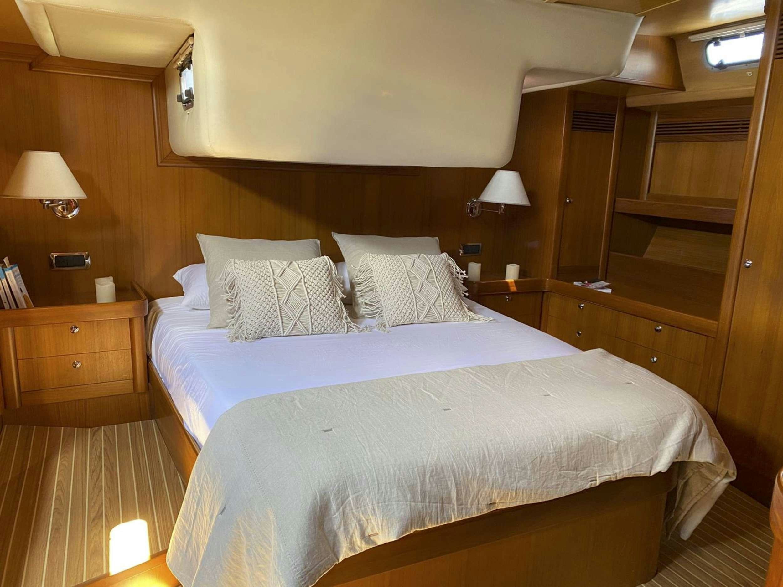 a bed with white sheets aboard COSTA NORD Yacht for Charter