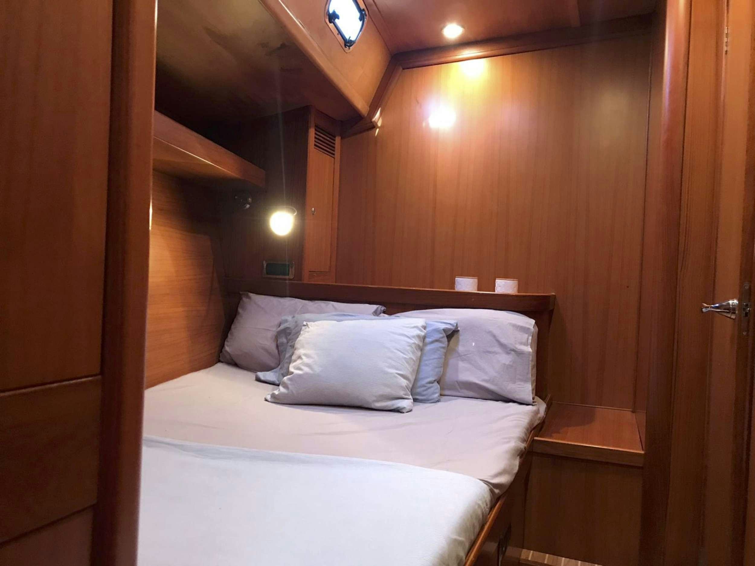 a bed with white sheets aboard COSTA NORD Yacht for Charter
