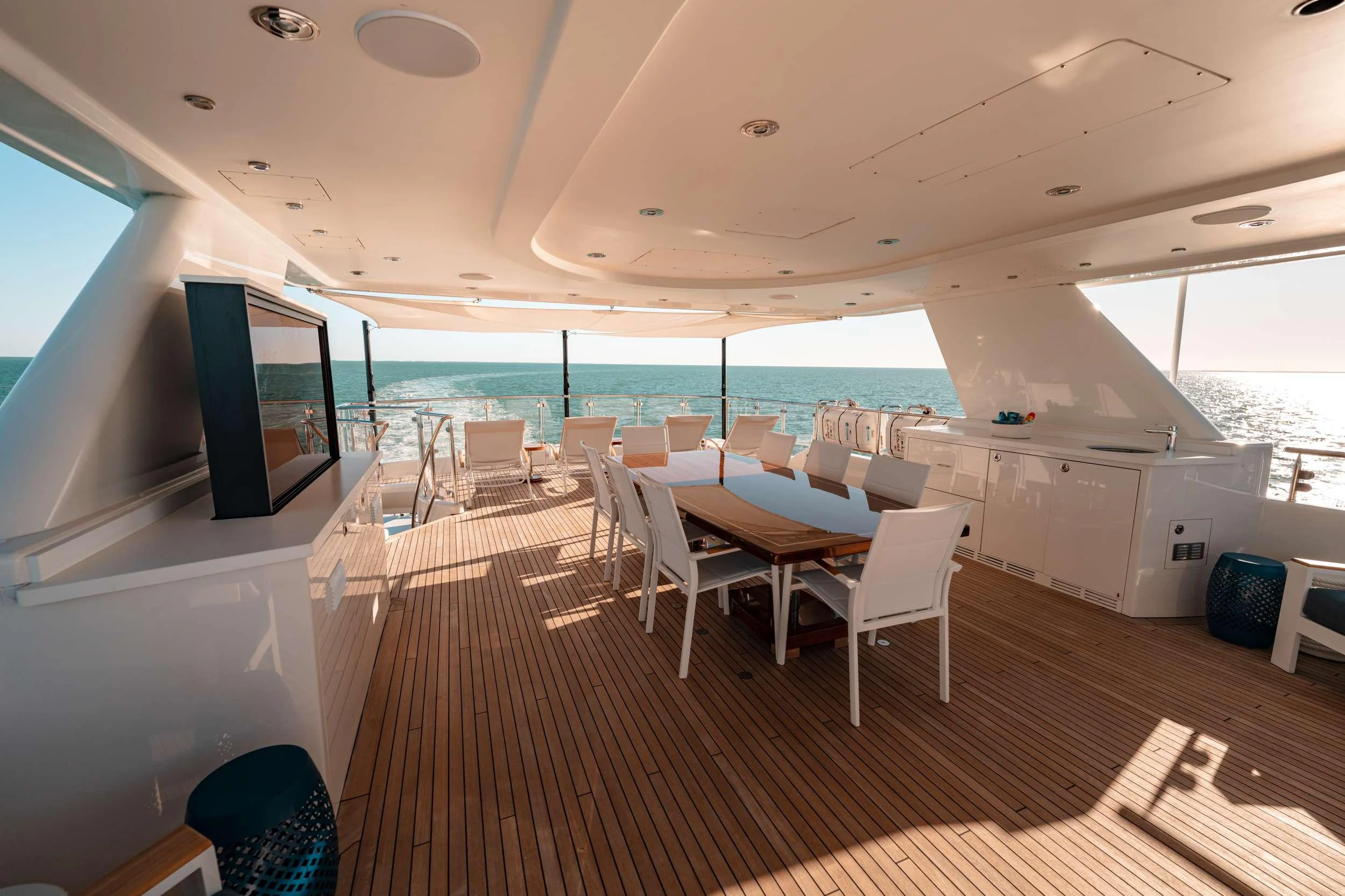 a room with a large window and a large wood floor with white chairs and a large window with aboard BLUE TIME Yacht for Charter