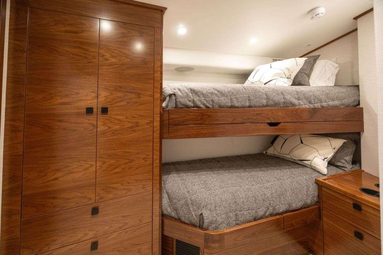 a bed with a wooden headboard aboard BOUJIE Yacht for Charter