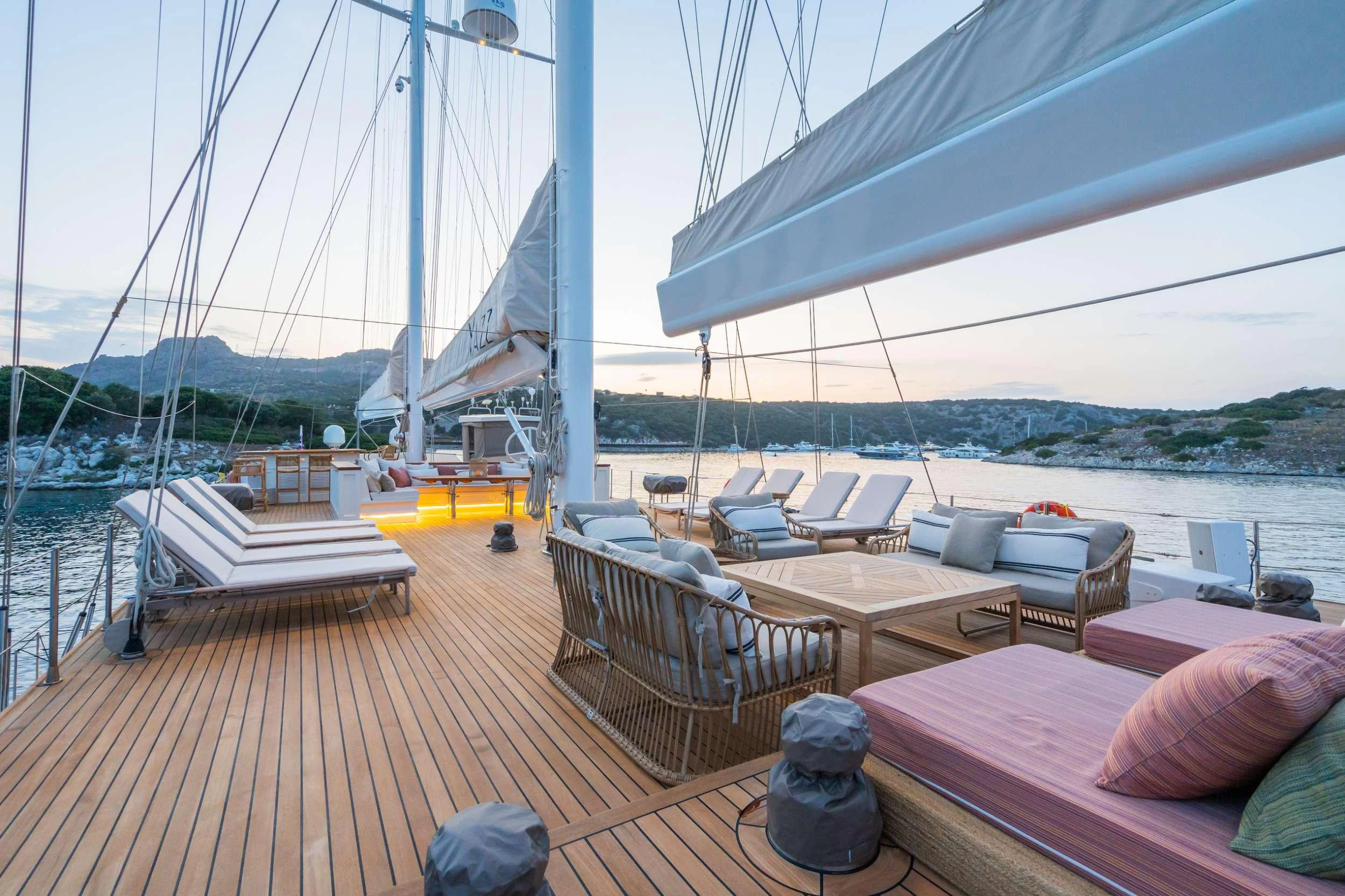a deck with a boat and a table on it aboard YAZZ Yacht for Charter