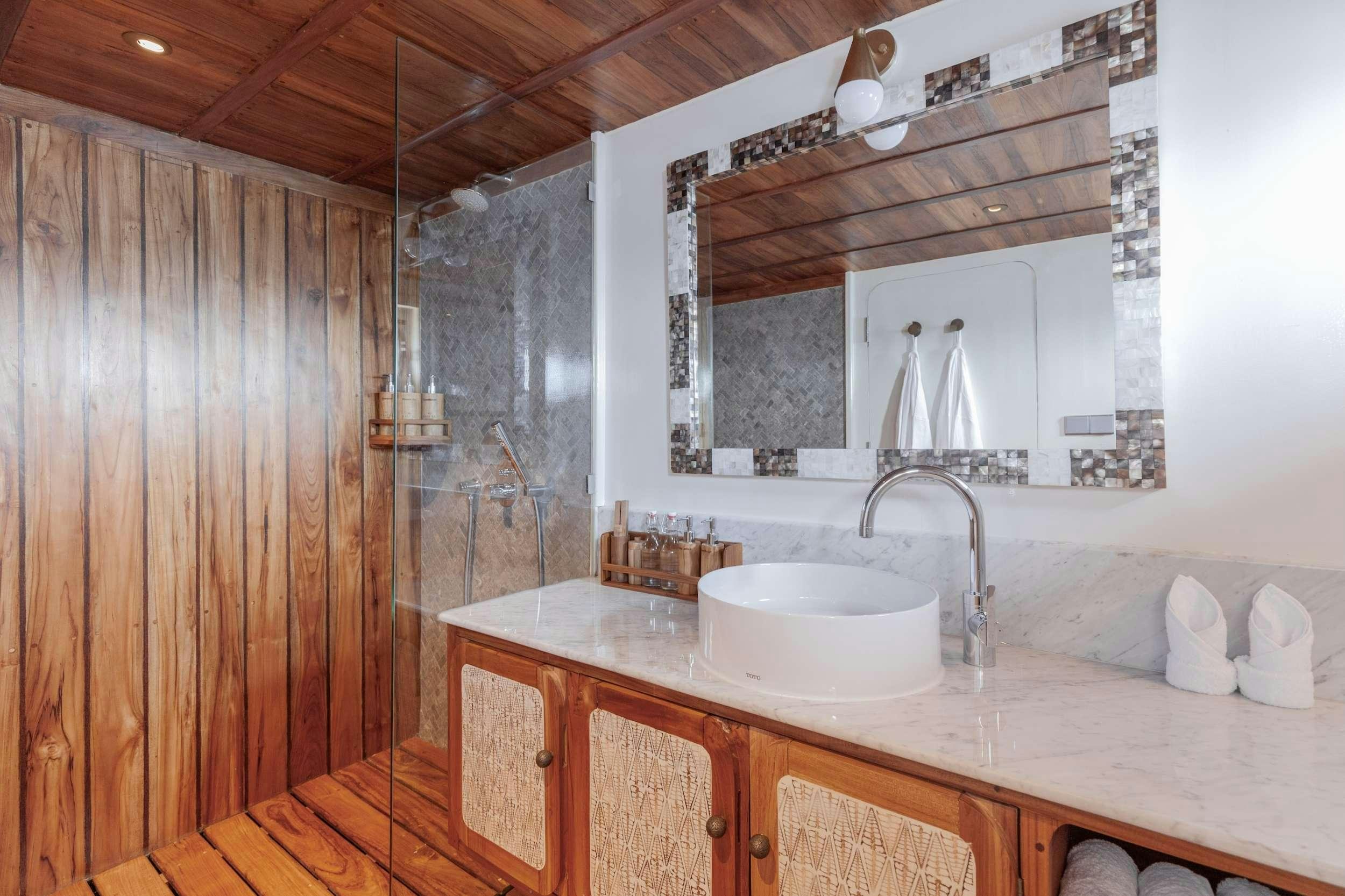 a bathroom with a sink and a large mirror aboard REBEL Yacht for Charter