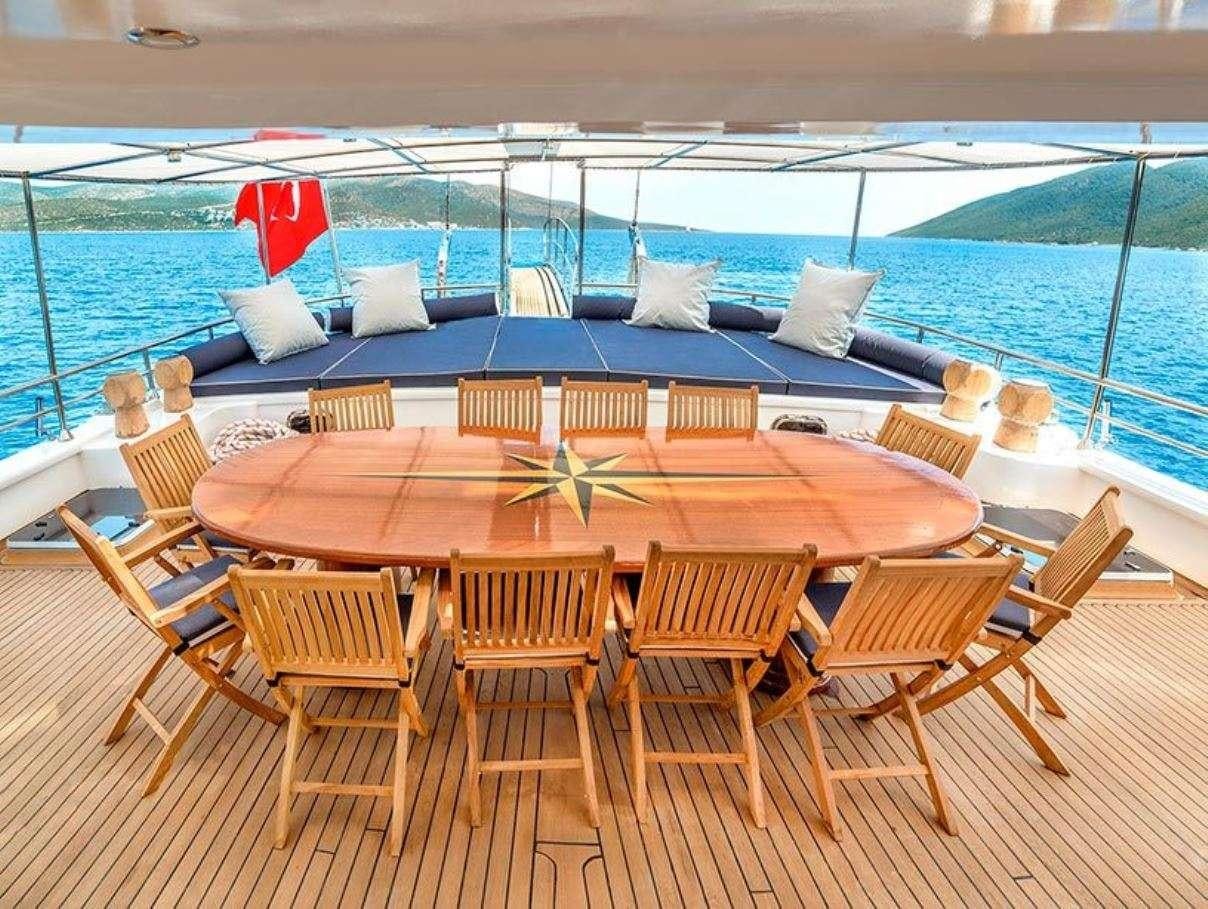 a wooden table on a deck overlooking a body of water aboard BELLA MARE Yacht for Charter