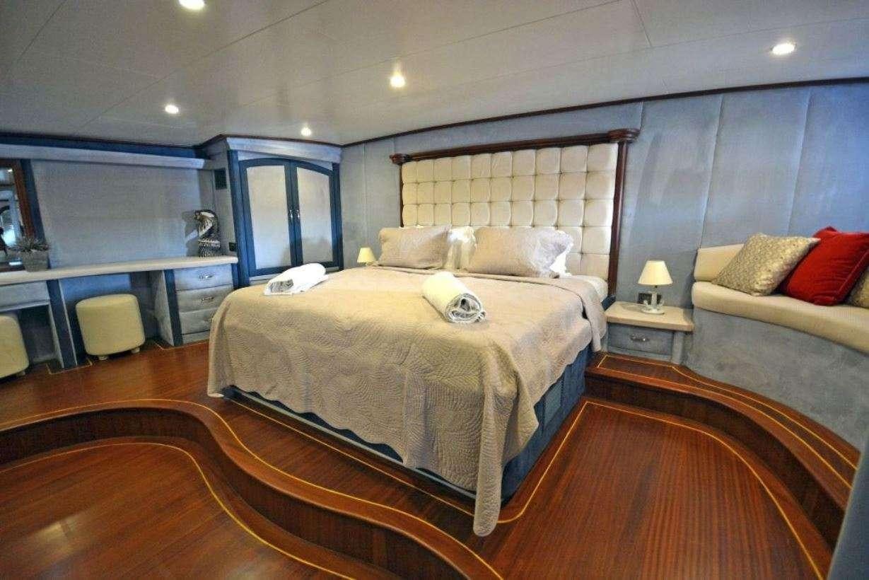 a bedroom with a bed and a desk aboard BELLA MARE Yacht for Charter