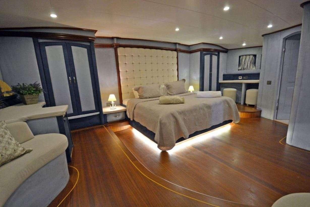 a large bedroom with a wood floor aboard BELLA MARE Yacht for Charter