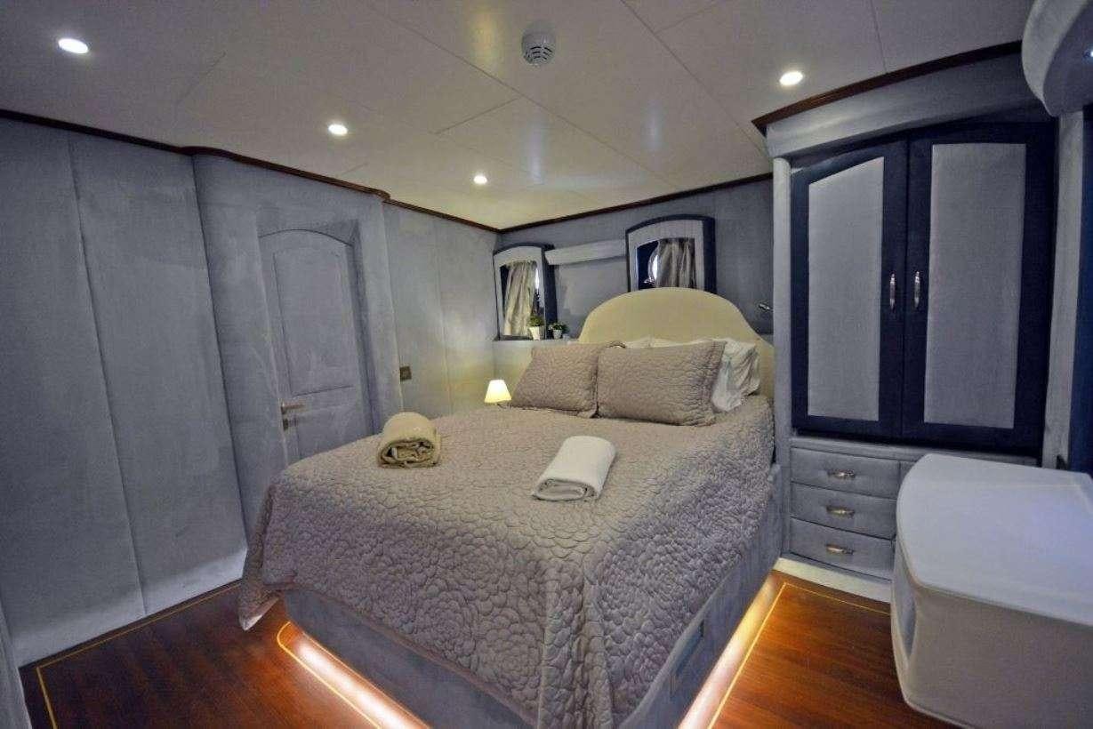 a bedroom with a bed and a mirror aboard BELLA MARE Yacht for Charter