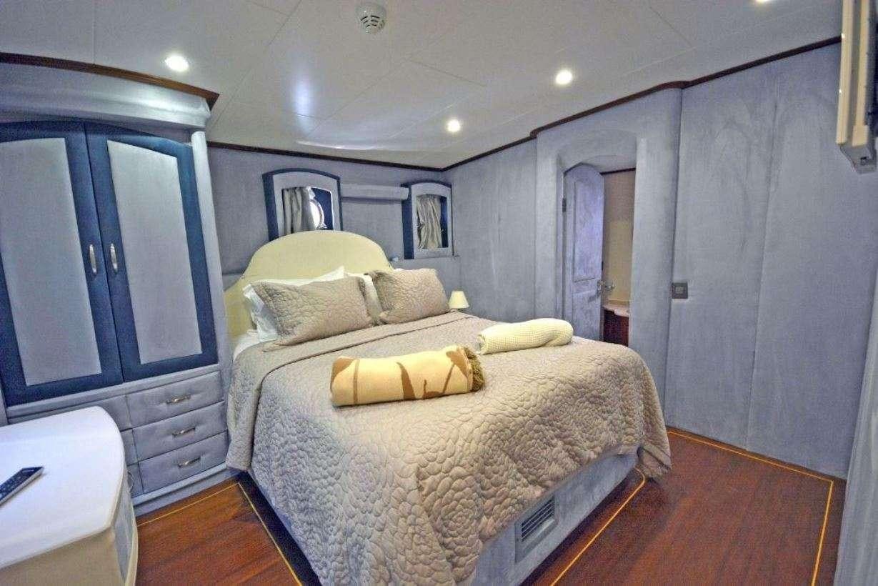 a bedroom with a bed and a desk aboard BELLA MARE Yacht for Charter