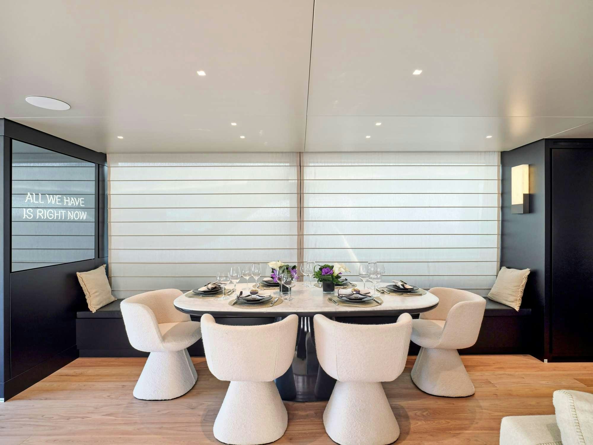 a table with chairs and a couch aboard MARY Yacht for Charter