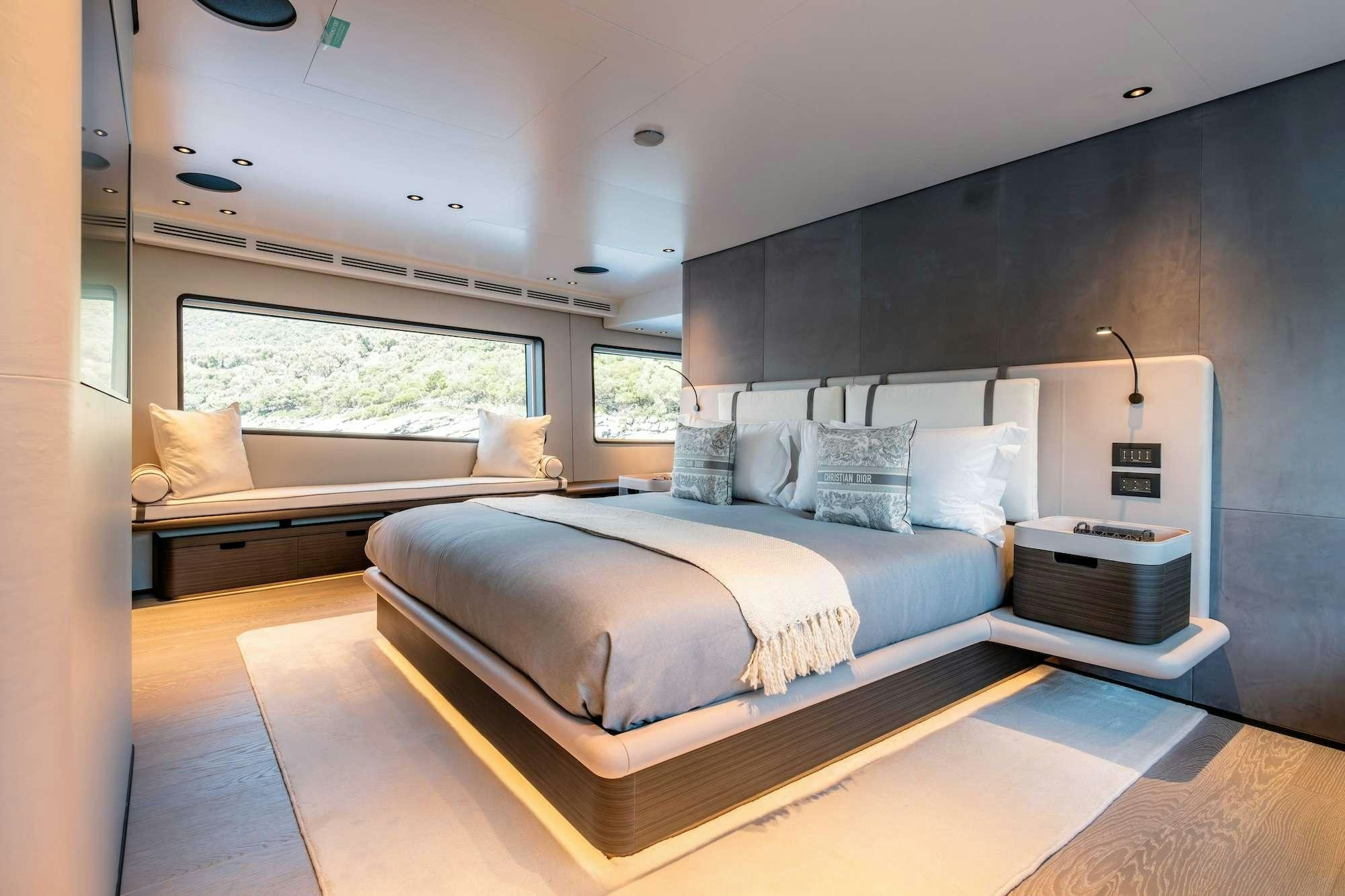 a bedroom with a bed and a window aboard AT ONE Yacht for Charter