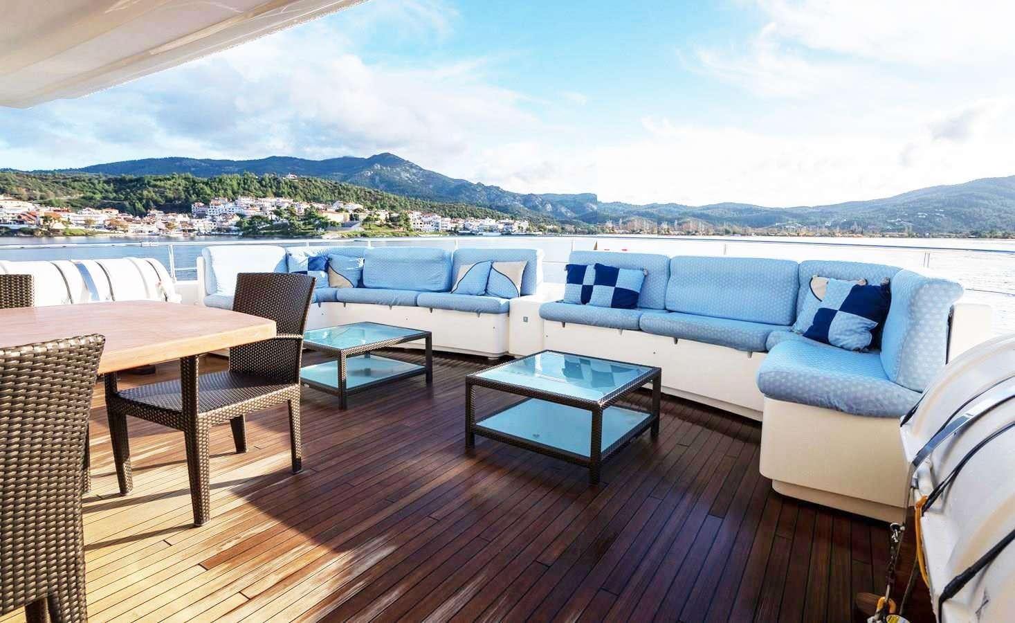 a deck with a table and chairs aboard PARADISE Yacht for Charter