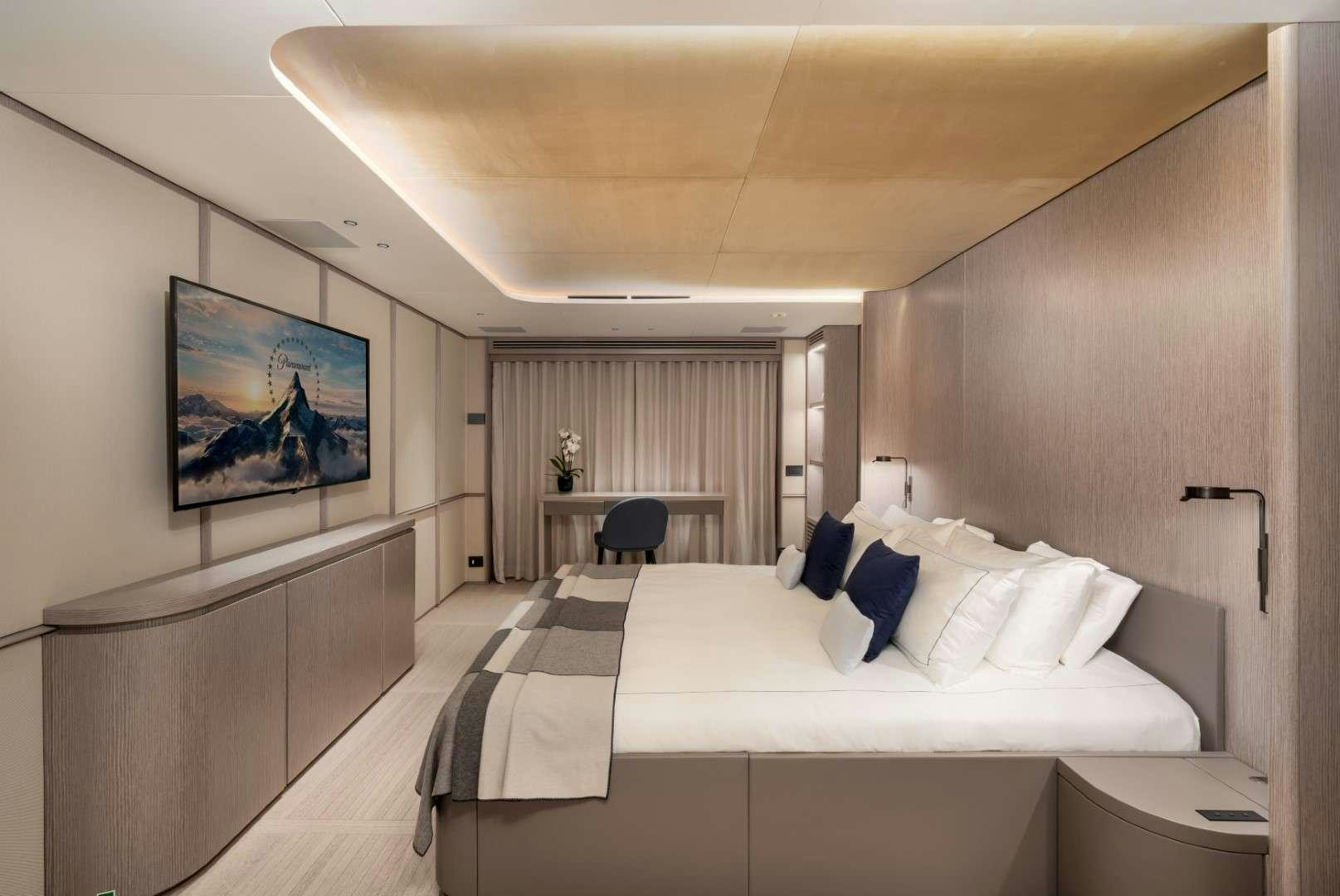 a room with a bed and a table aboard KINGS LAIR Yacht for Charter