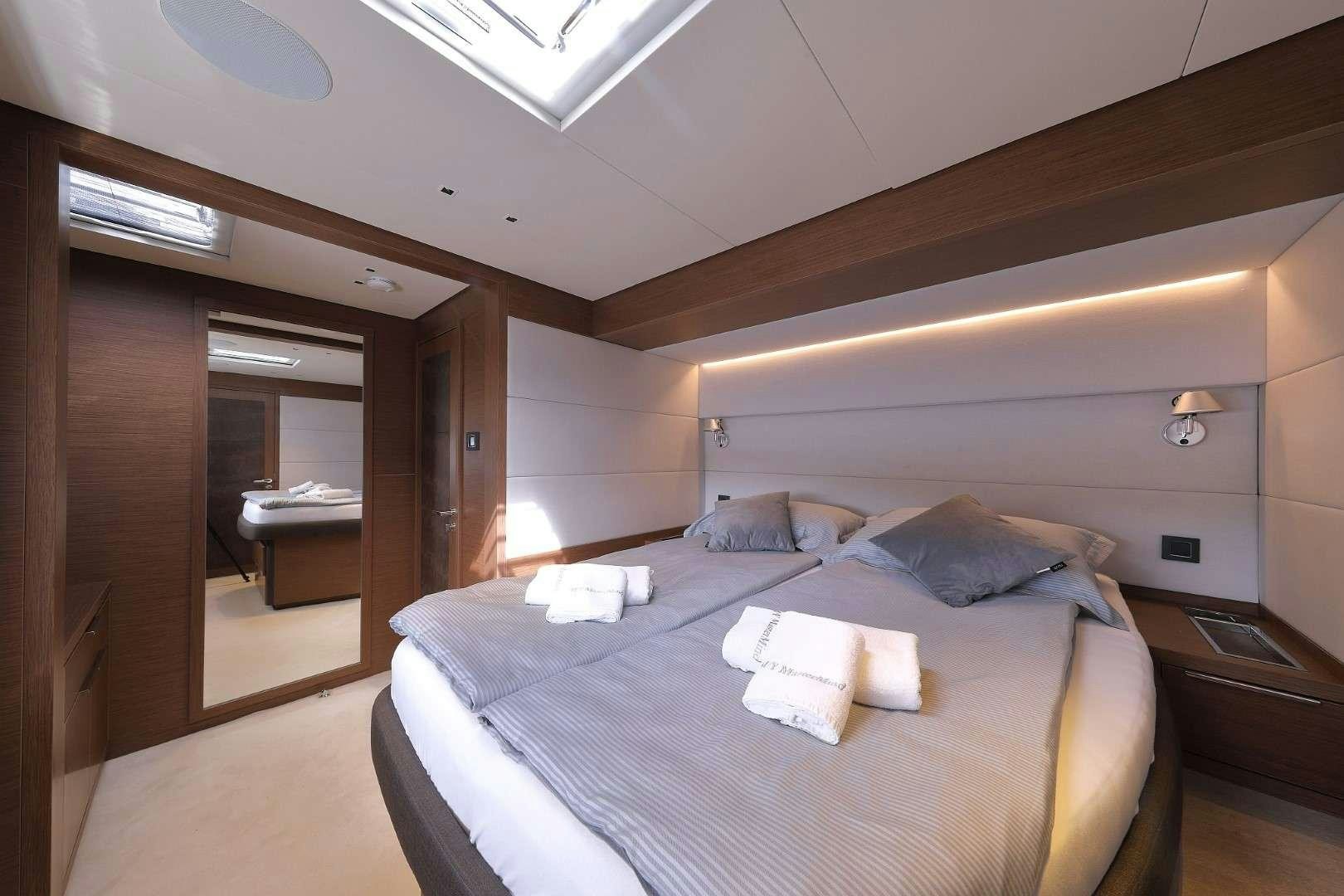 a room with a bed and a mirror aboard MASTERMIND Yacht for Charter