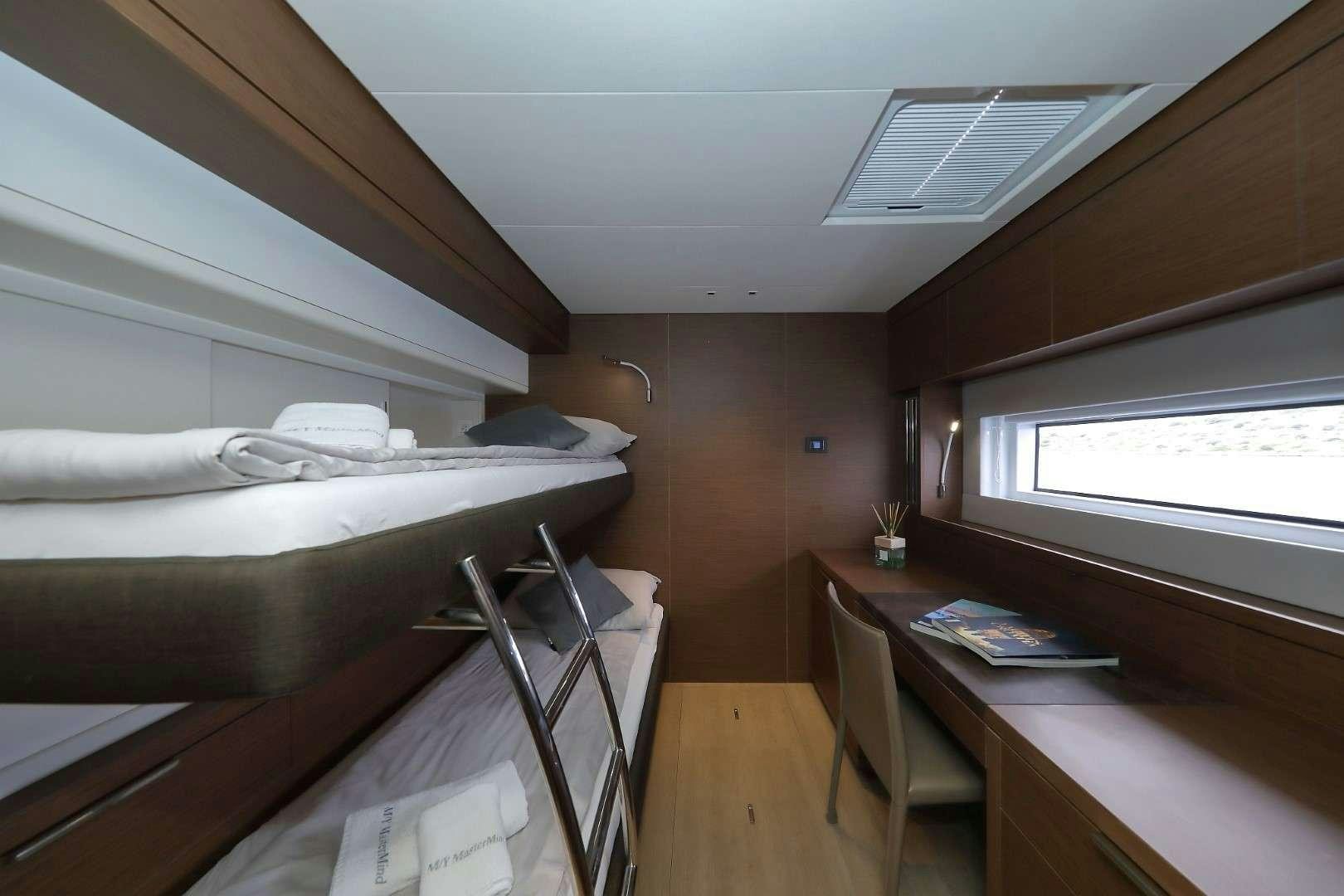 a room with a bed and desk aboard MASTERMIND Yacht for Charter