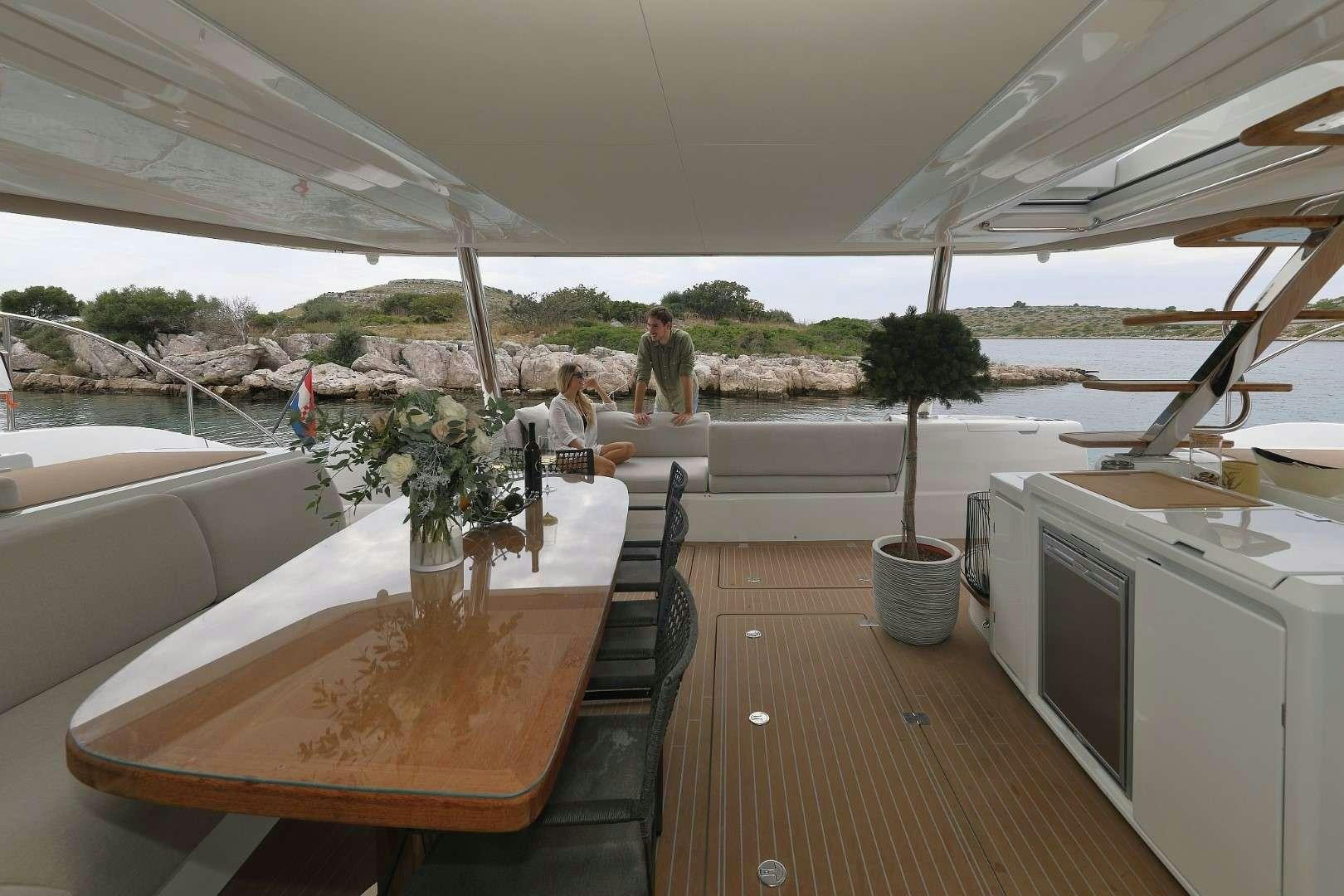 a group of people sitting at a table outside aboard MASTERMIND Yacht for Charter