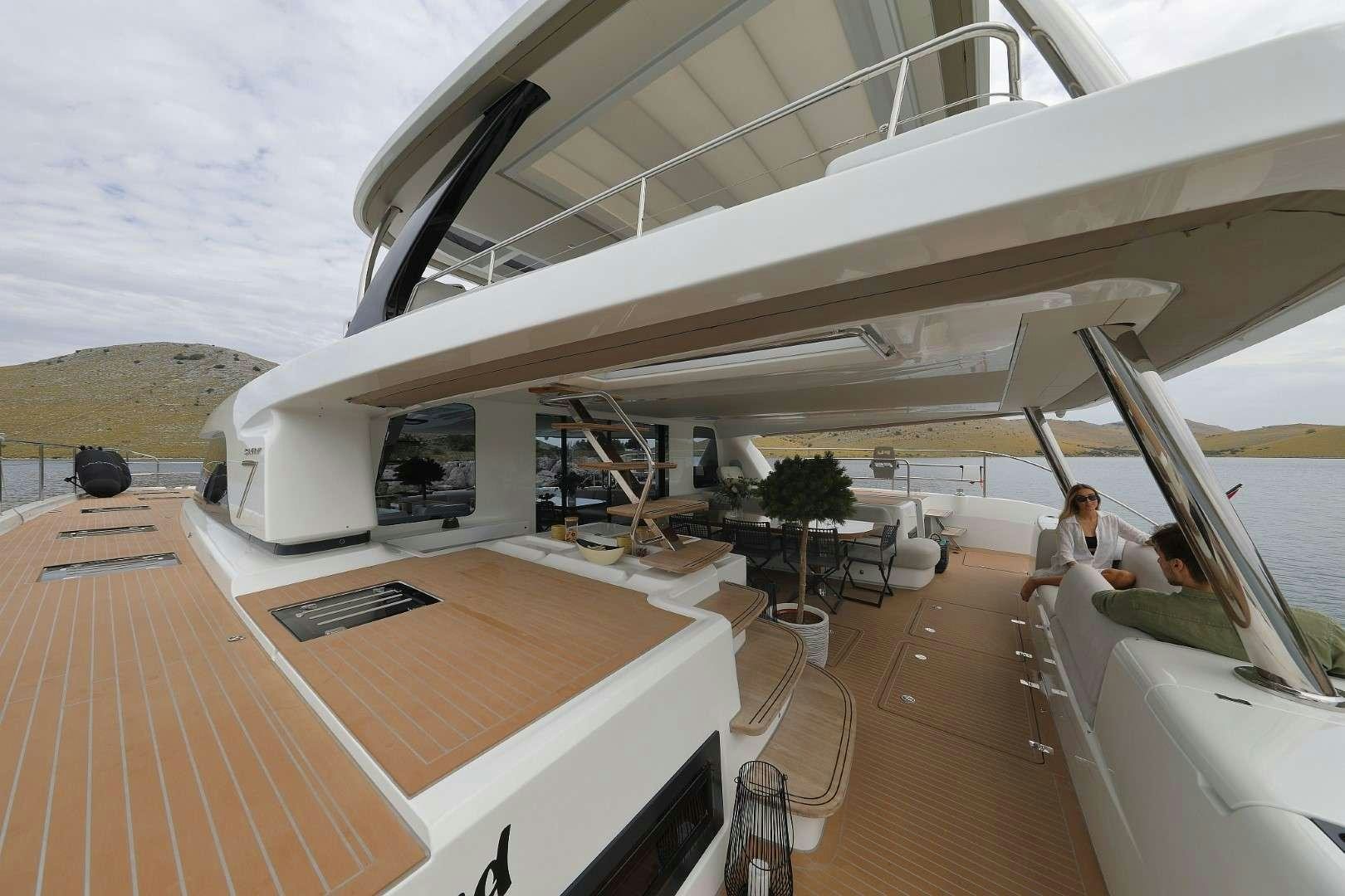 a large white boat with a person sitting on it aboard MASTERMIND Yacht for Charter
