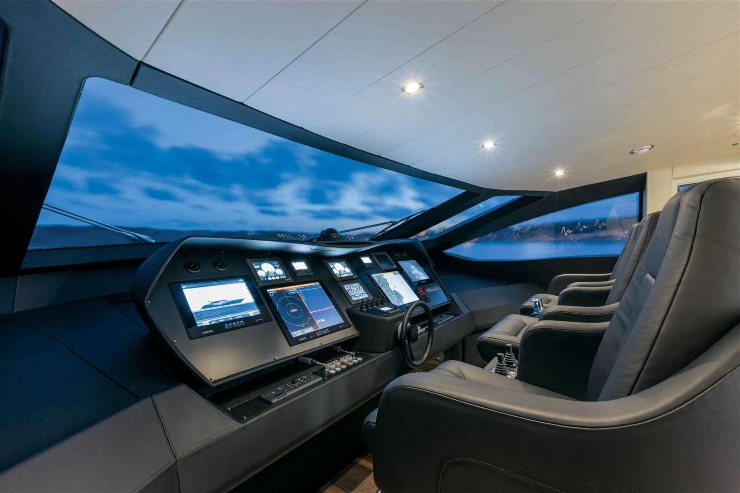 inside of a car with a screen and windows and a view of the water aboard NAAV Yacht for Charter