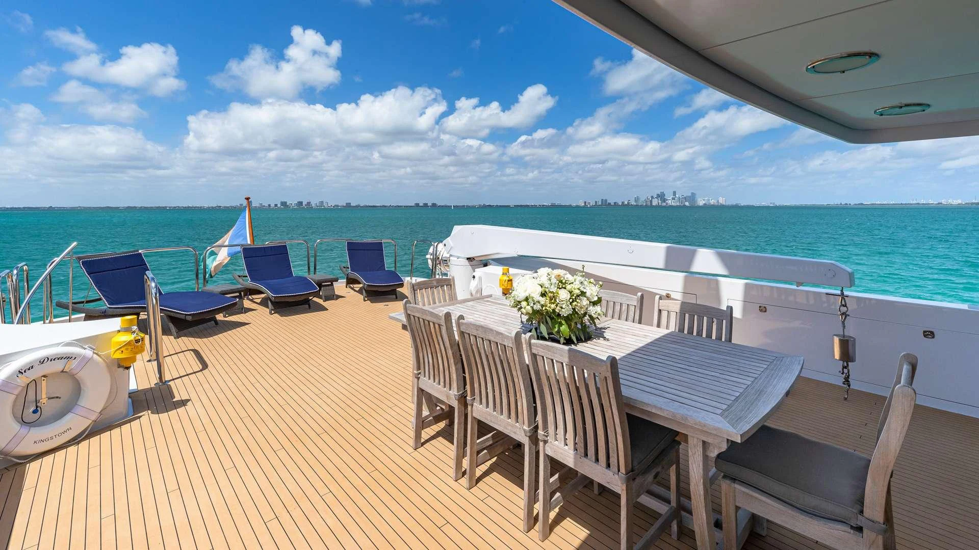 a deck with chairs and tables on it by the ocean aboard SEA DREAMS Yacht for Charter