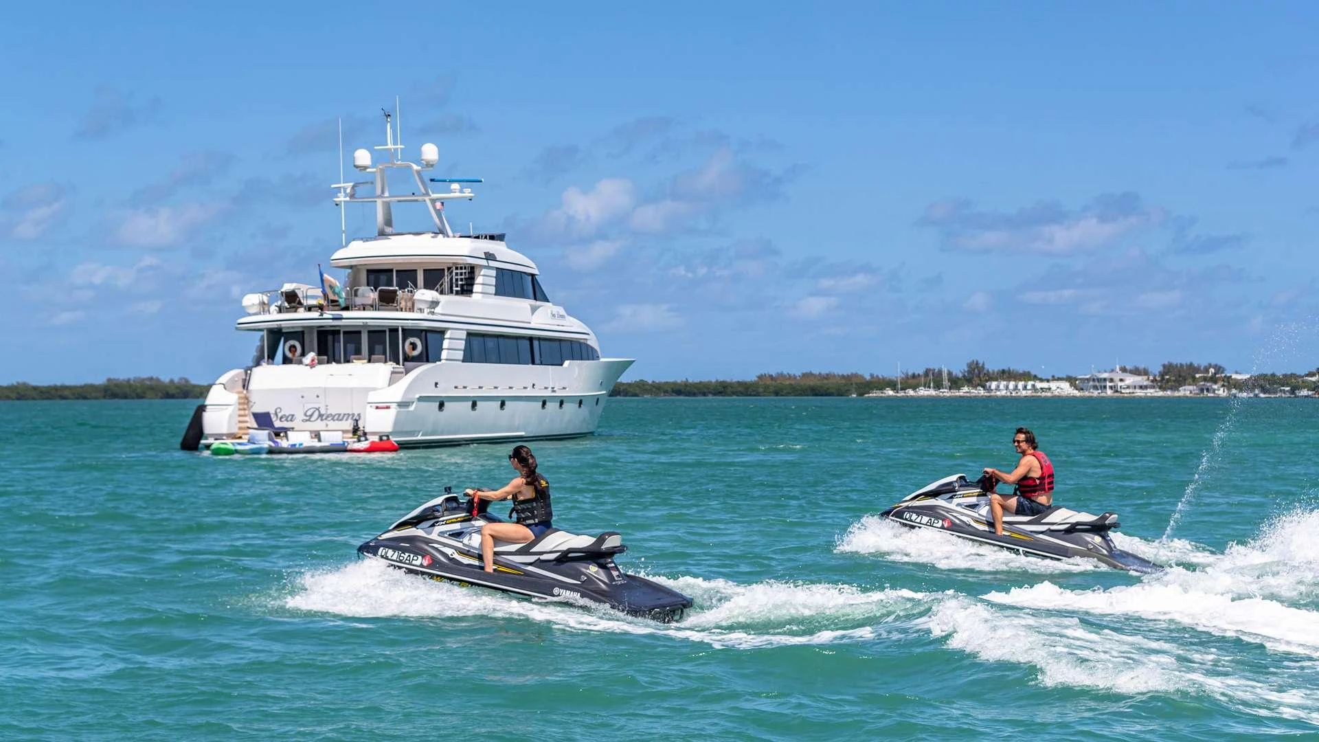a boat and a couple of people in a motorboat aboard SEA DREAMS Yacht for Charter