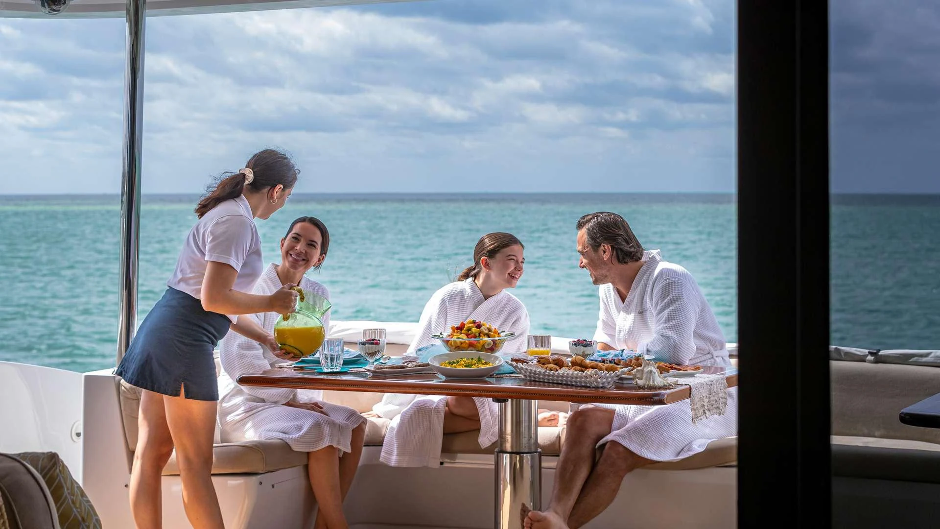 a group of people sitting around a table with food on it aboard SEA DREAMS Yacht for Charter