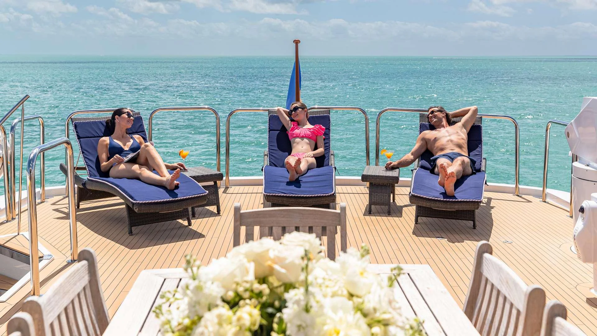a group of people sitting on a deck overlooking the ocean aboard SEA DREAMS Yacht for Charter