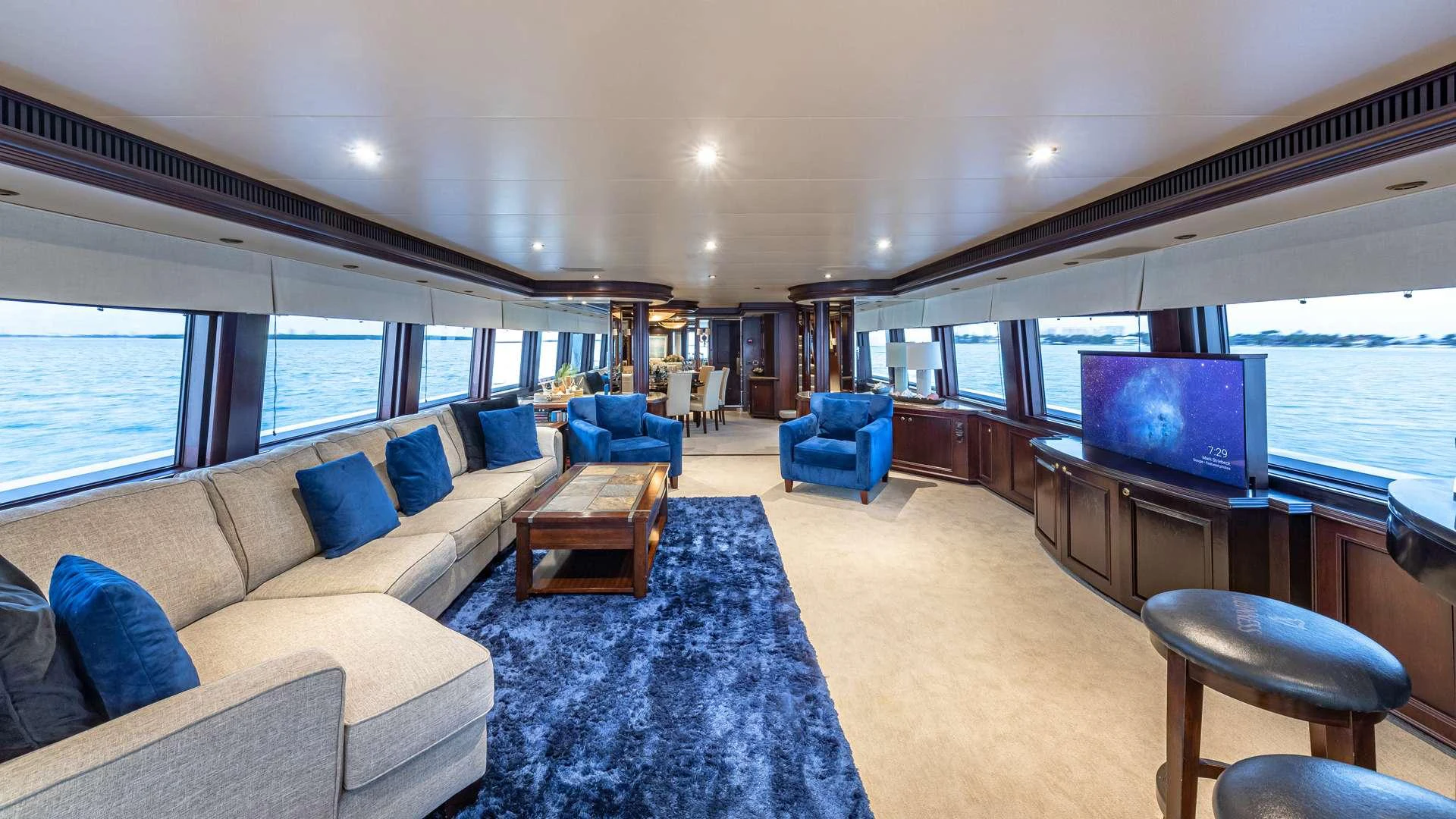 a living room with a large blue rug and a large television aboard SEA DREAMS Yacht for Charter