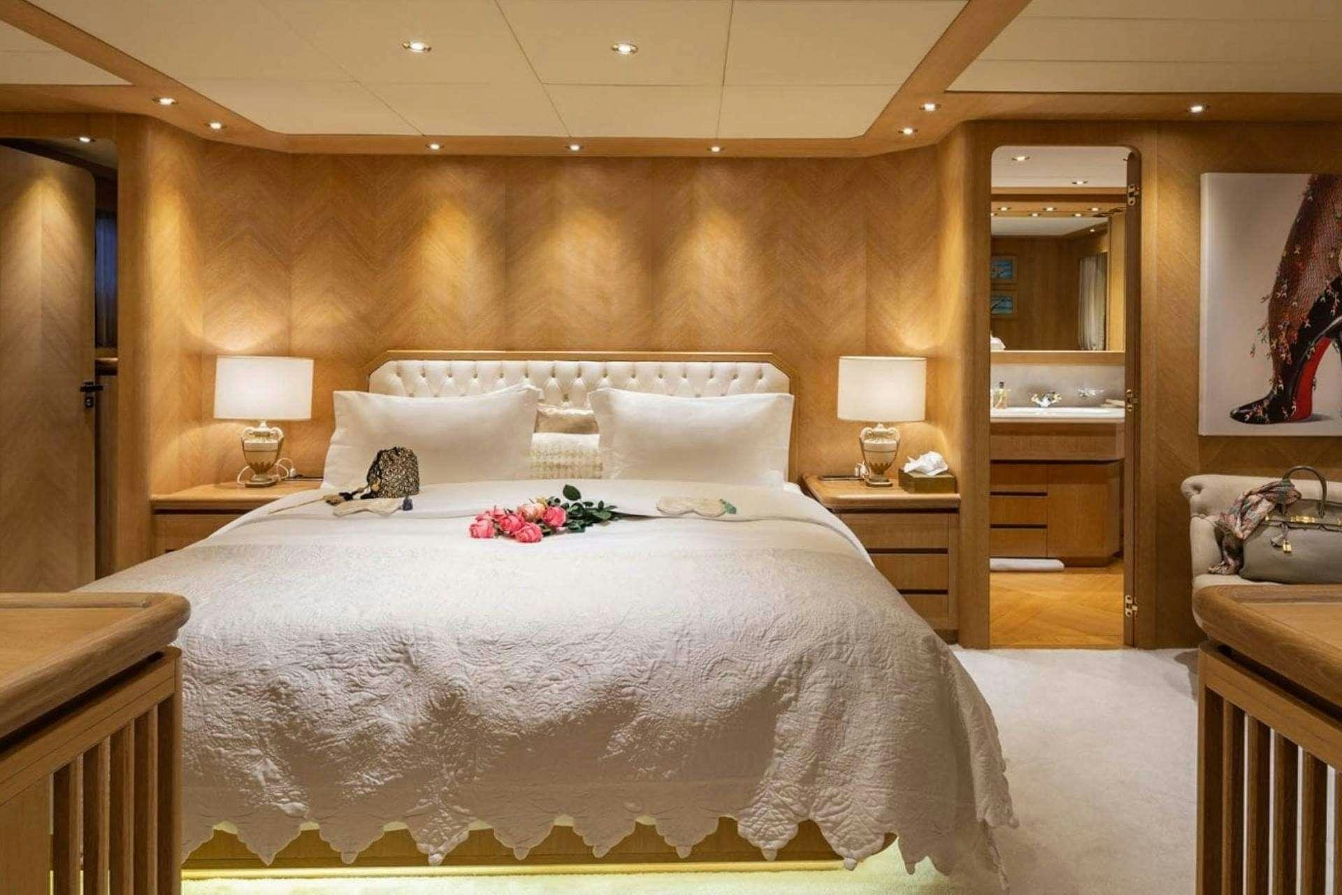 a bed with white sheets aboard NOVA Yacht for Charter