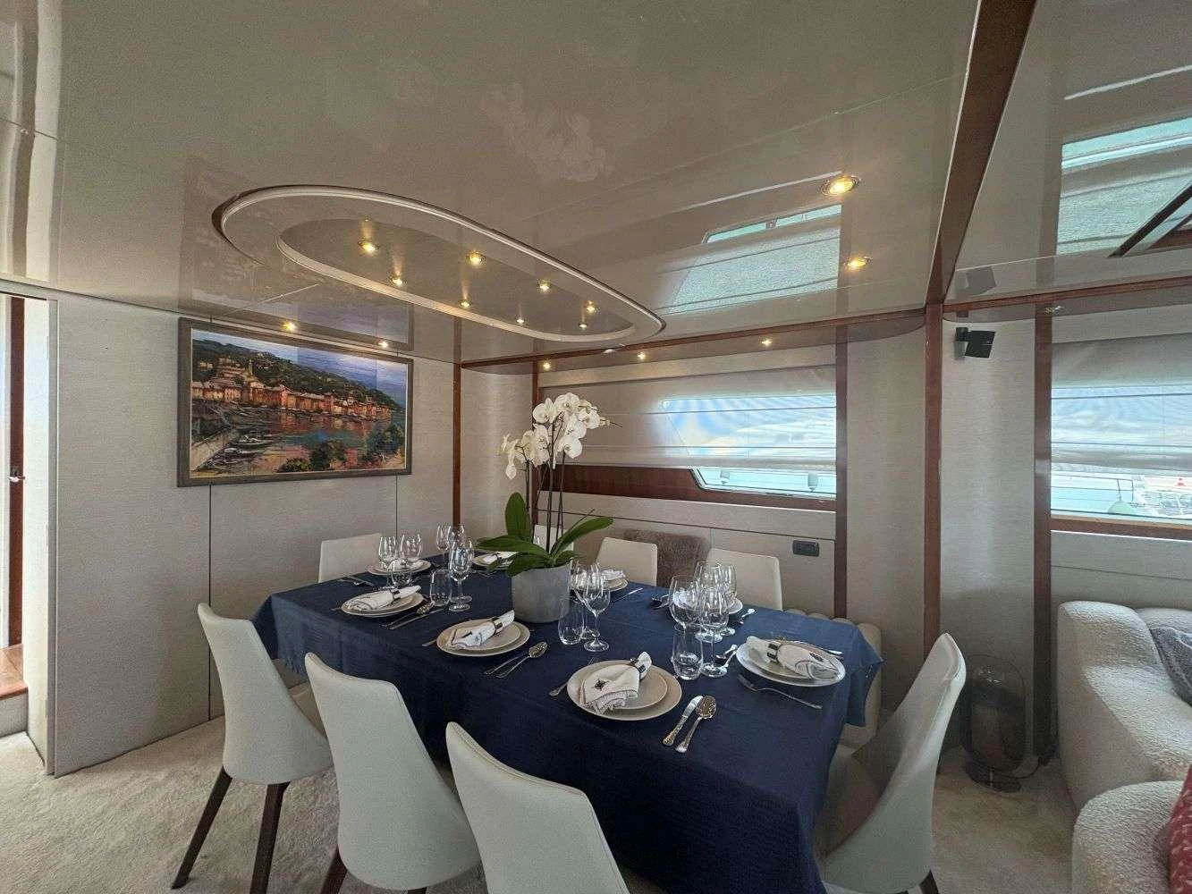 a dining room with a blue tablecloth and white chairs aboard MAMMA'S Yacht for Charter
