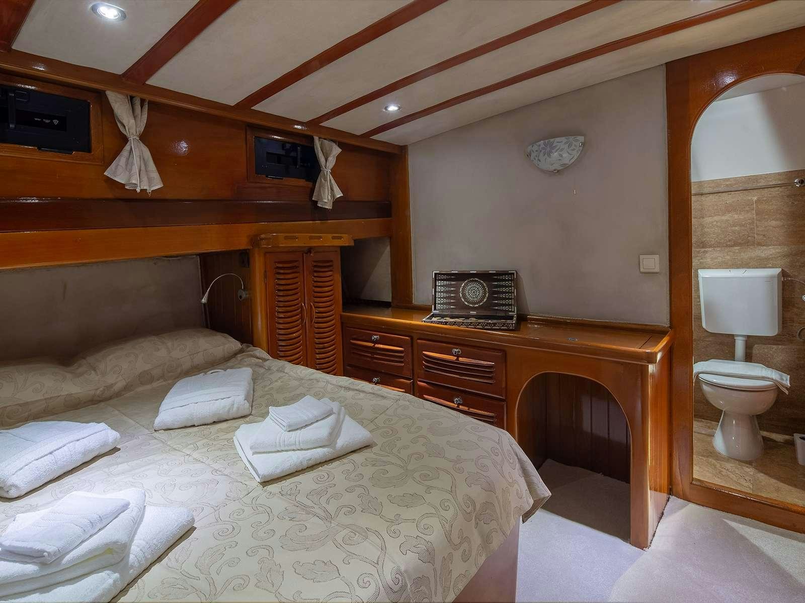 a bedroom with a bed and a desk aboard ELEGANZA Yacht for Charter