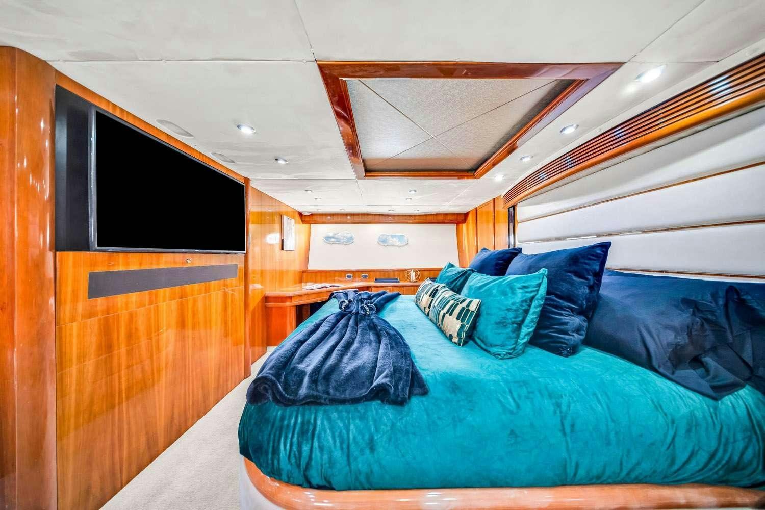 a bed with a blue comforter aboard SO WHAT WHO CARES Yacht for Charter