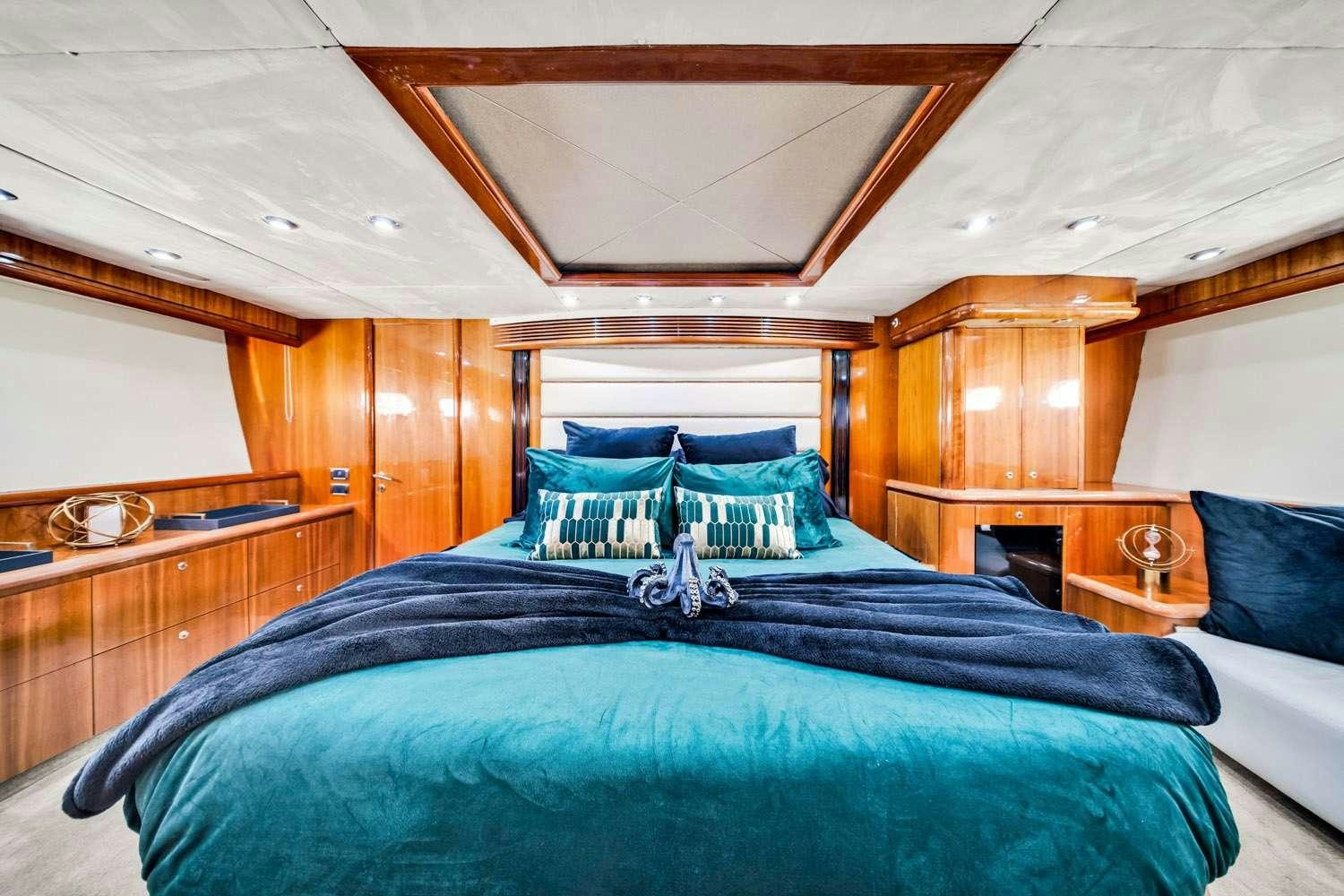 a bed with a blue comforter aboard SO WHAT WHO CARES Yacht for Charter