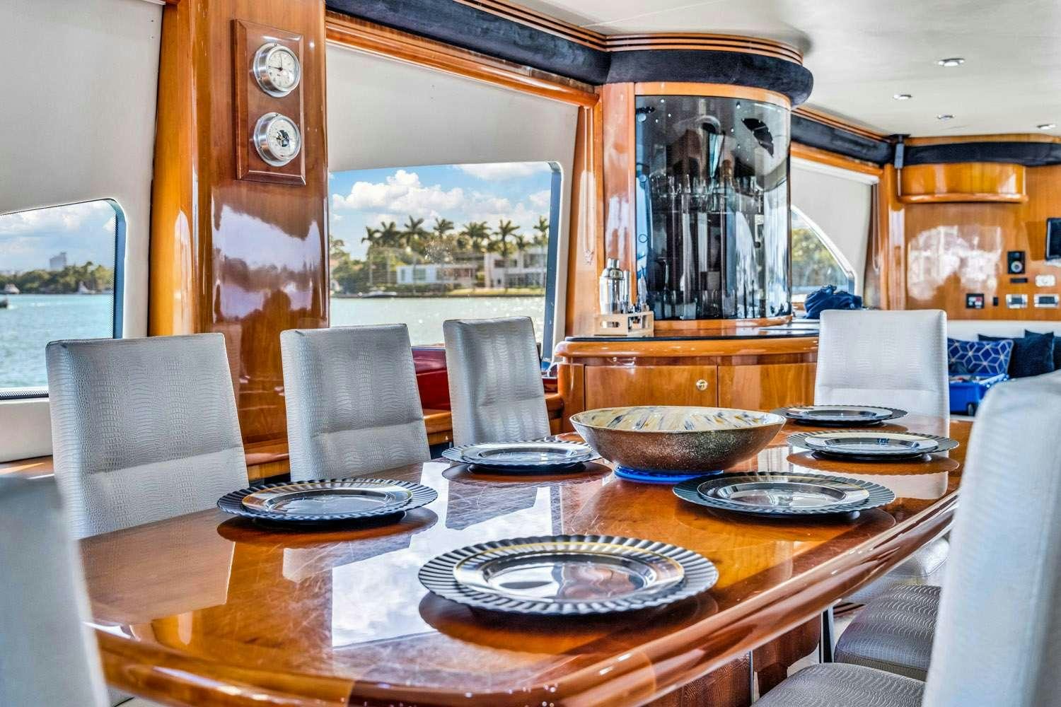 a dining room table with plates and chairs aboard SO WHAT WHO CARES Yacht for Charter