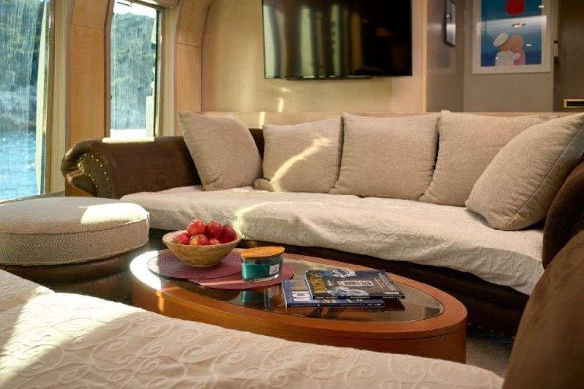 a couch with a coffee table and a bowl of fruit on it aboard MARSHALL Yacht for Charter