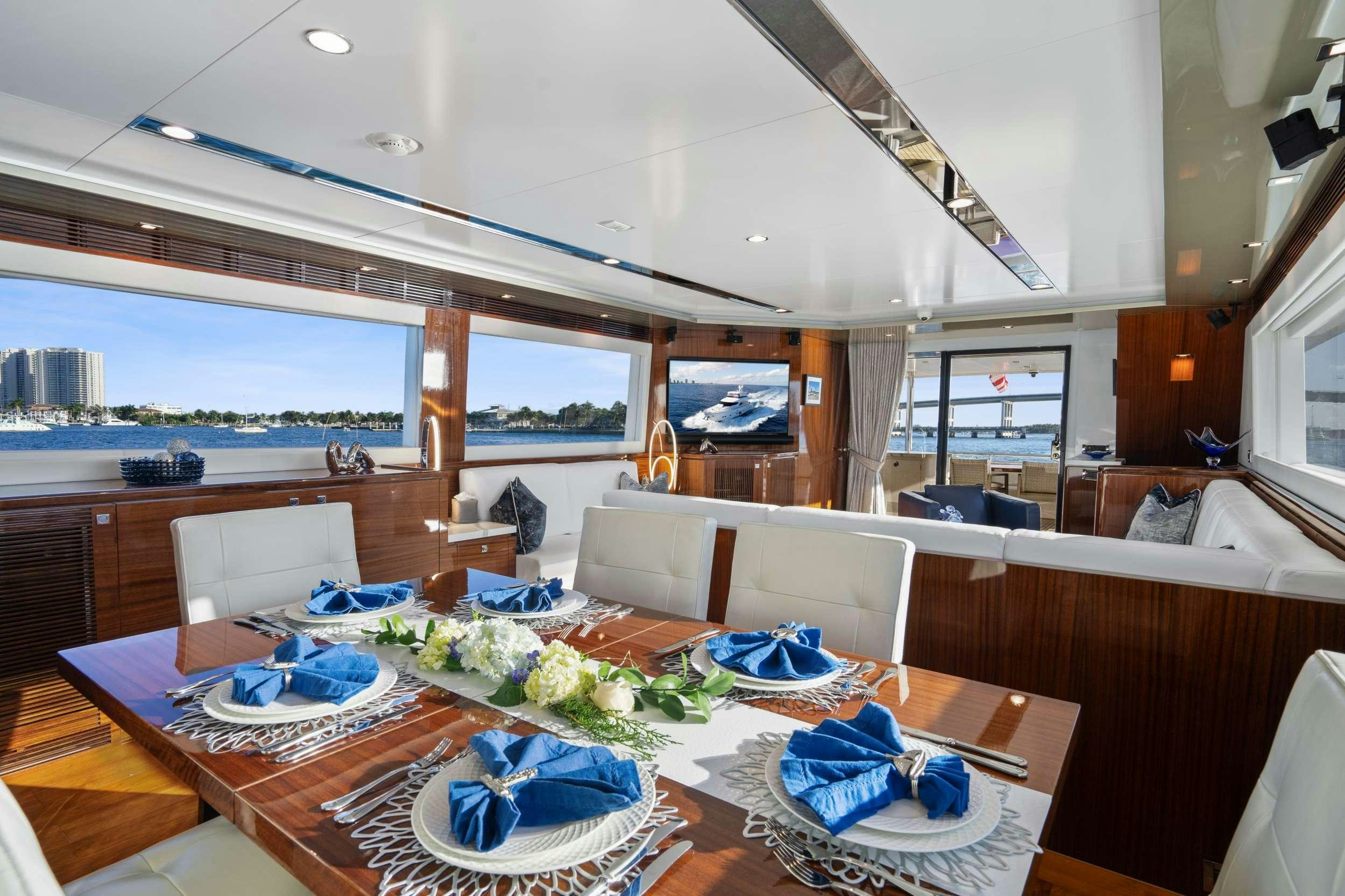 a large living room with a large table and chairs aboard PILOT LOUNGE Yacht for Charter