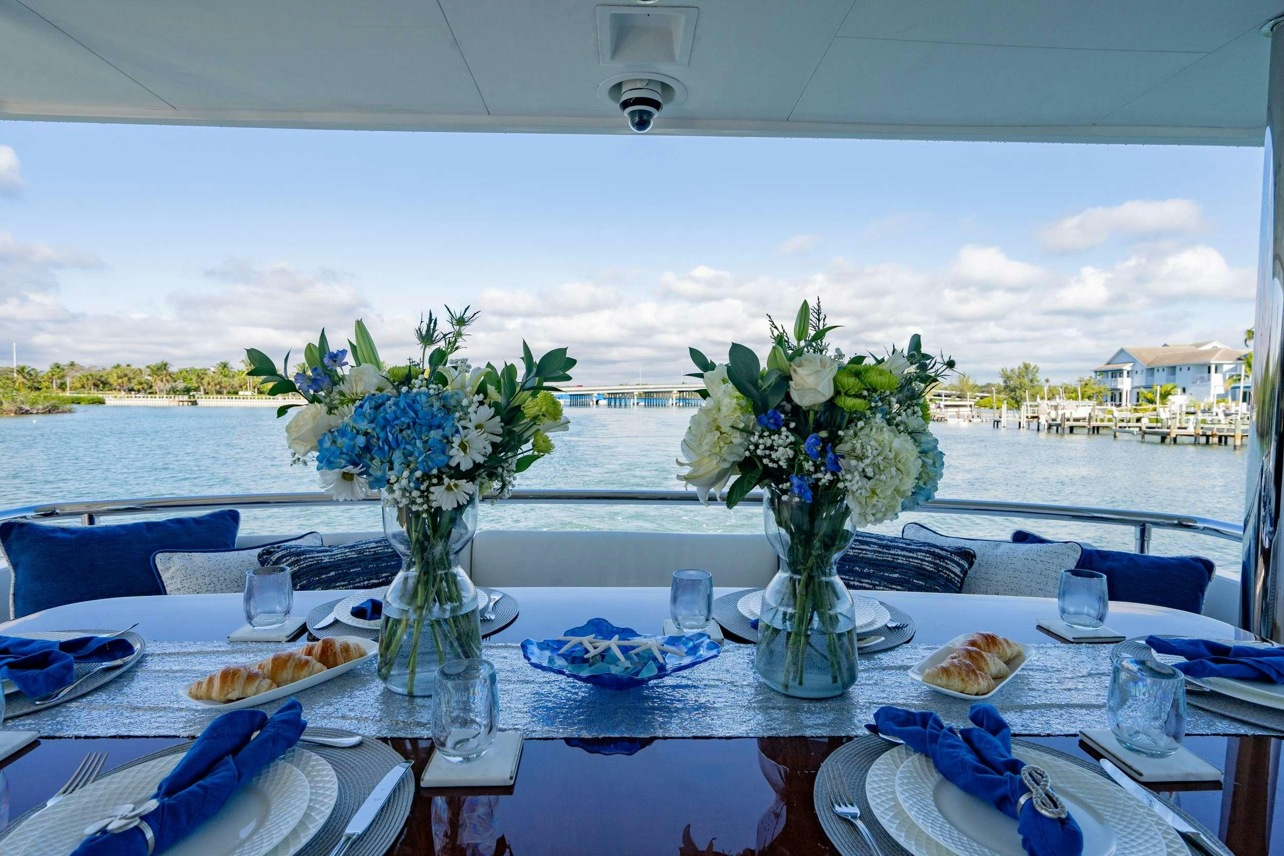 a table with plates and flowers aboard PILOT LOUNGE Yacht for Charter