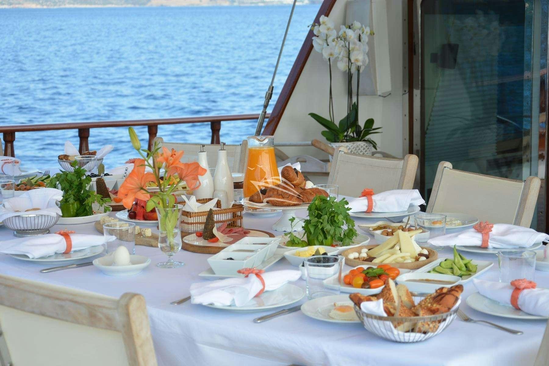 a table set with food and flowers aboard PAPA JOE Yacht for Charter