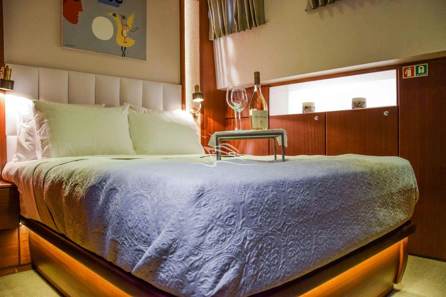 a bed with a glass of wine aboard PAPA JOE Yacht for Charter