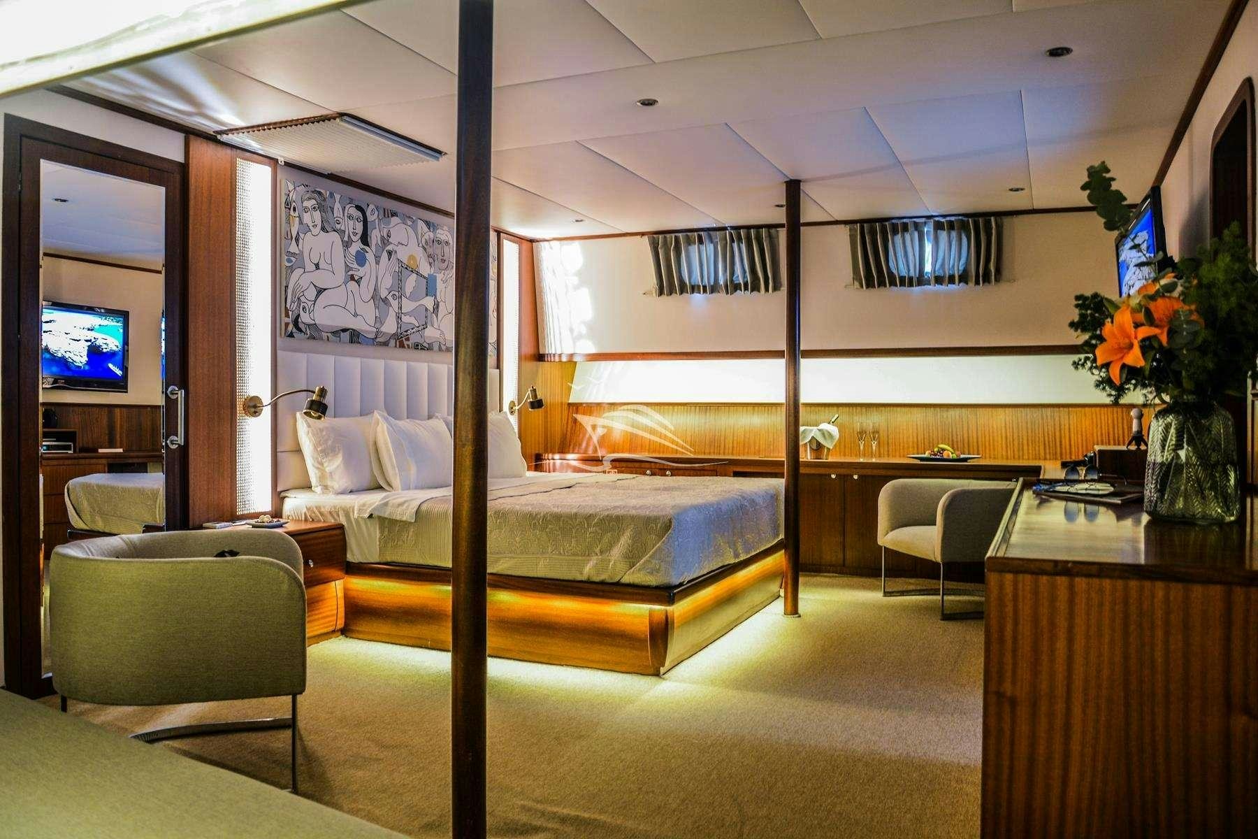 a bedroom with a bed and desk aboard PAPA JOE Yacht for Charter