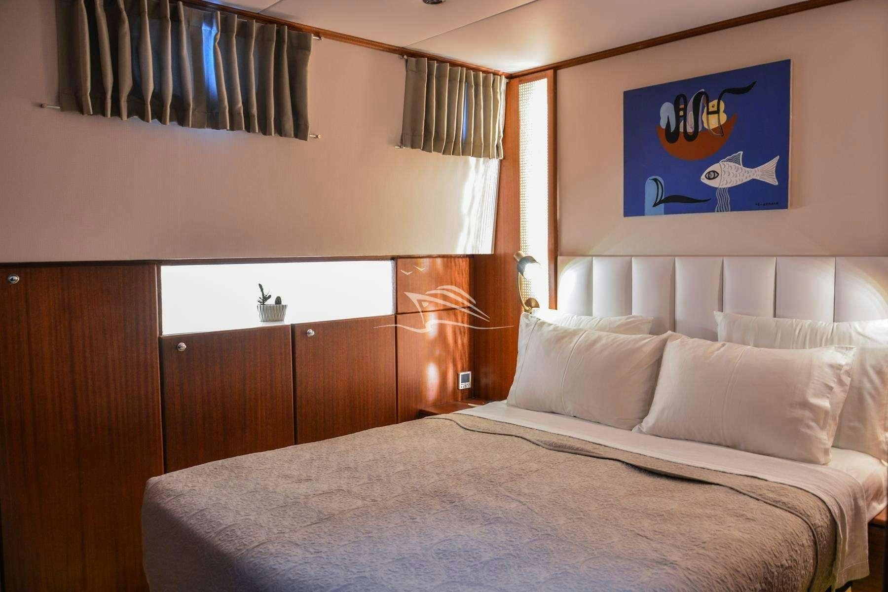 a bed with white sheets aboard PAPA JOE Yacht for Charter