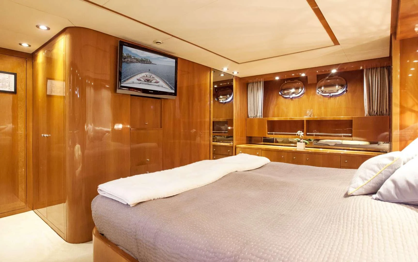 a room with a bed and a television aboard SOLAL Yacht for Charter