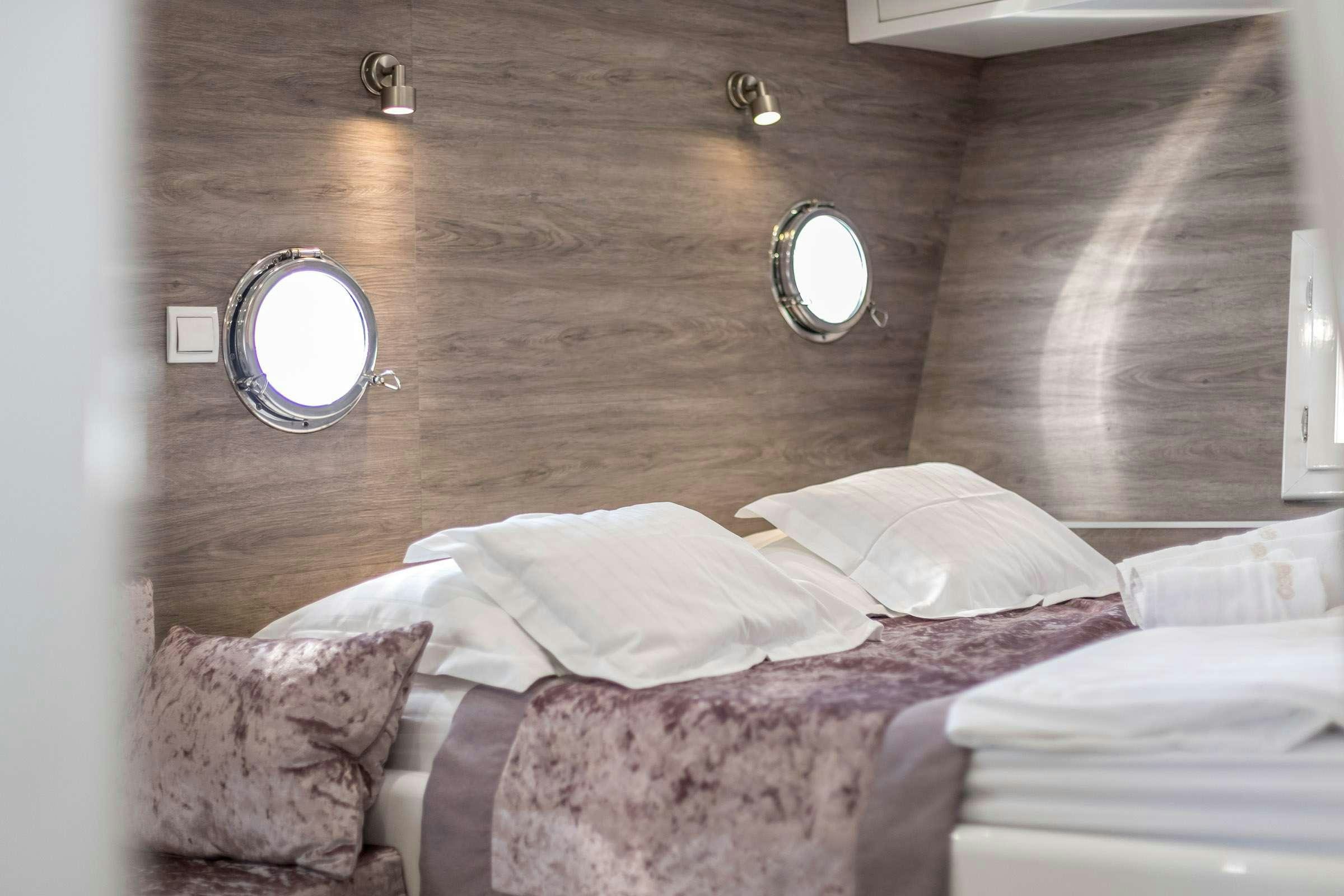 a bed with a mirror above it aboard ANĐEO Yacht for Charter