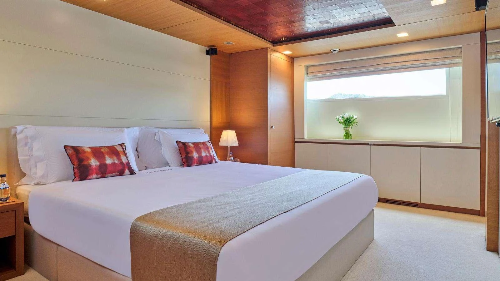 a bed with a white bed spread aboard KINTARO Yacht for Charter