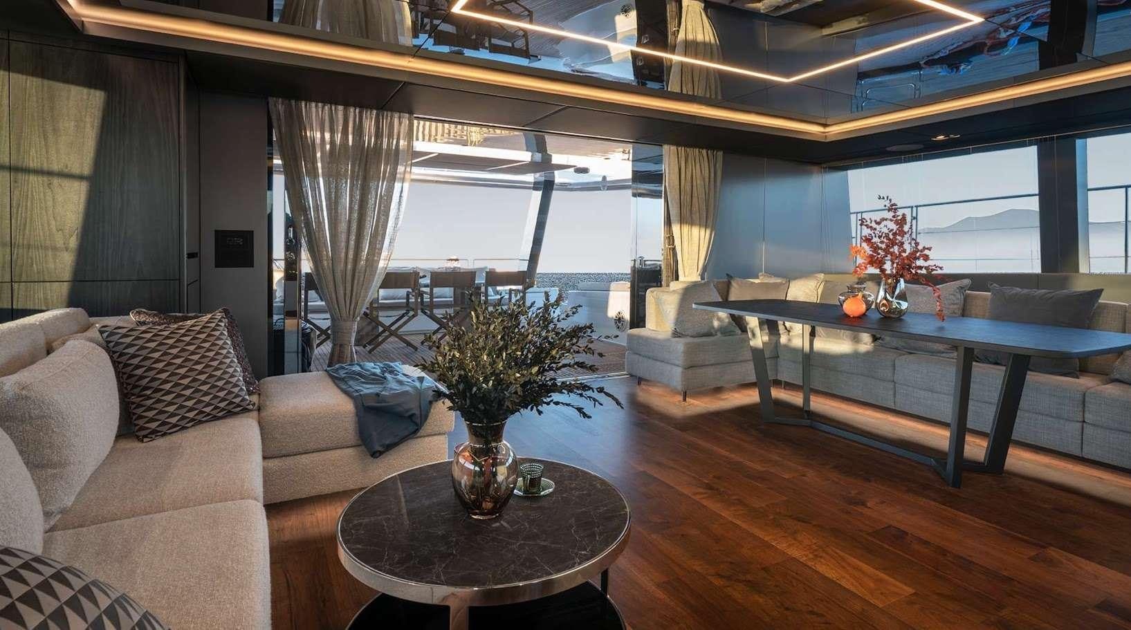 a living room with a table and couches aboard ALTEYA Yacht for Charter