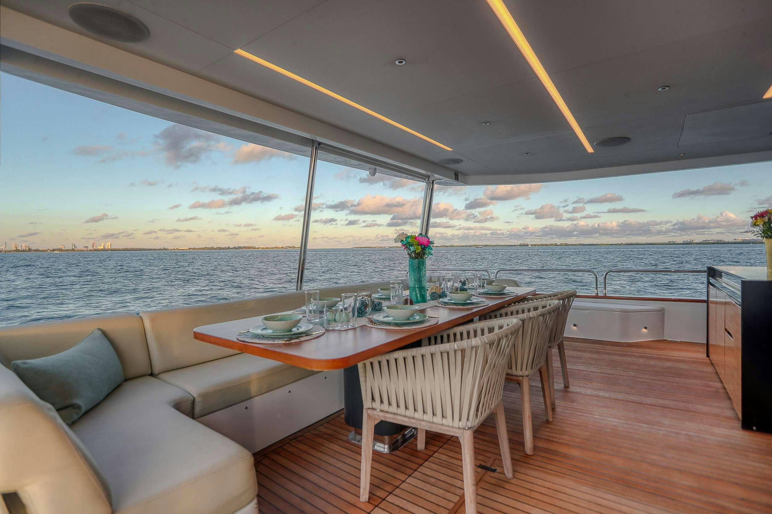a table and chairs on a deck overlooking a body of water aboard SAINT Yacht for Charter
