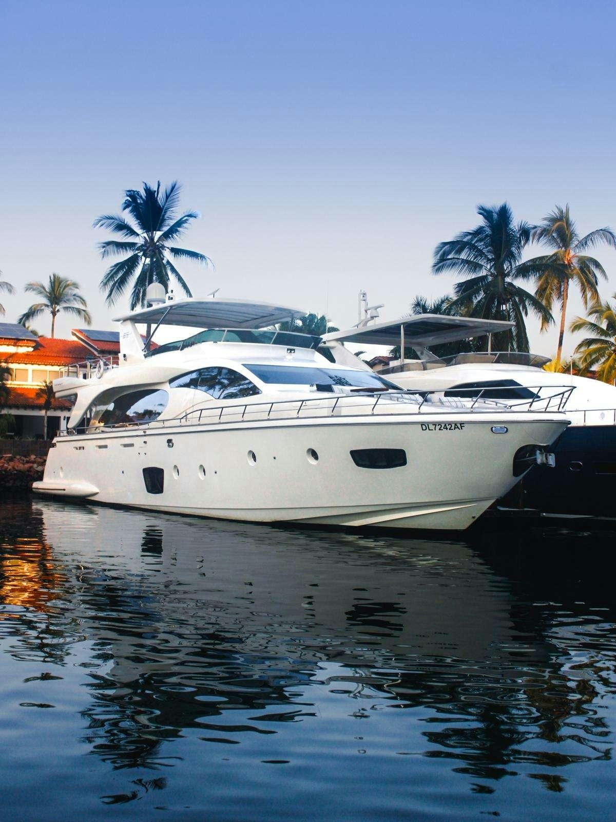 a white yacht docked at a dock aboard EL GABO Yacht for Charter