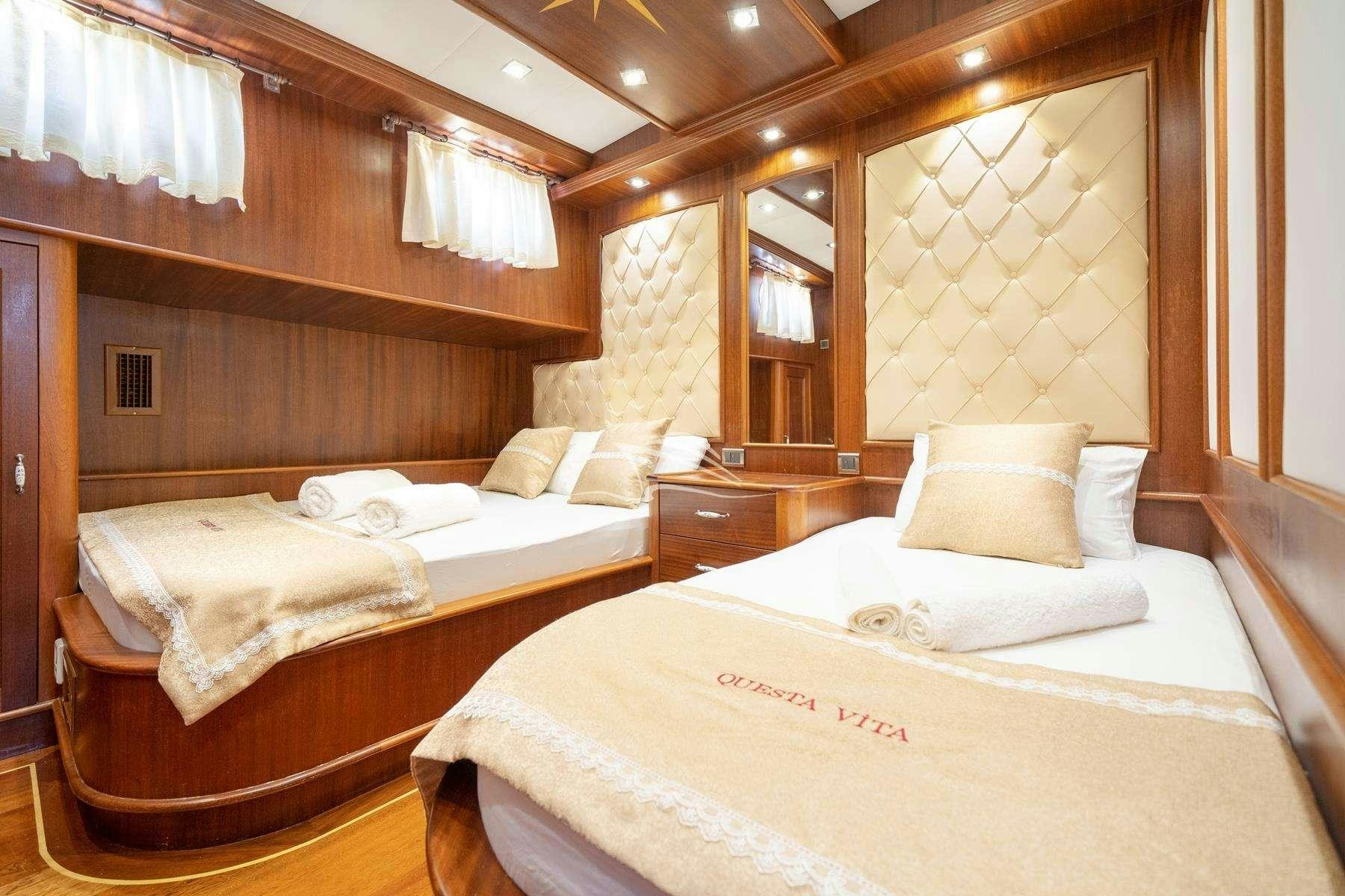 a room with a couple of beds aboard QUESTA VITA Yacht for Charter