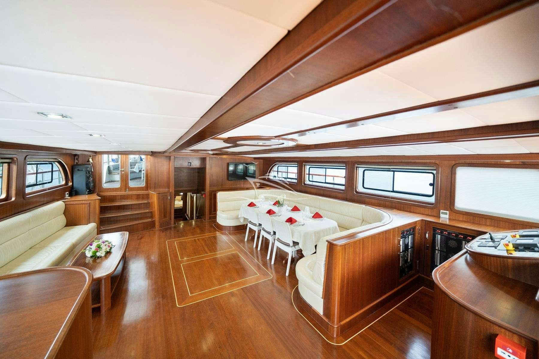 a room with a bed and a table aboard QUESTA VITA Yacht for Charter