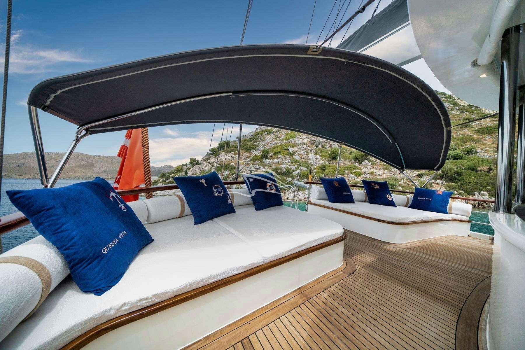 a tent with a deck and a view of the mountains aboard QUESTA VITA Yacht for Charter