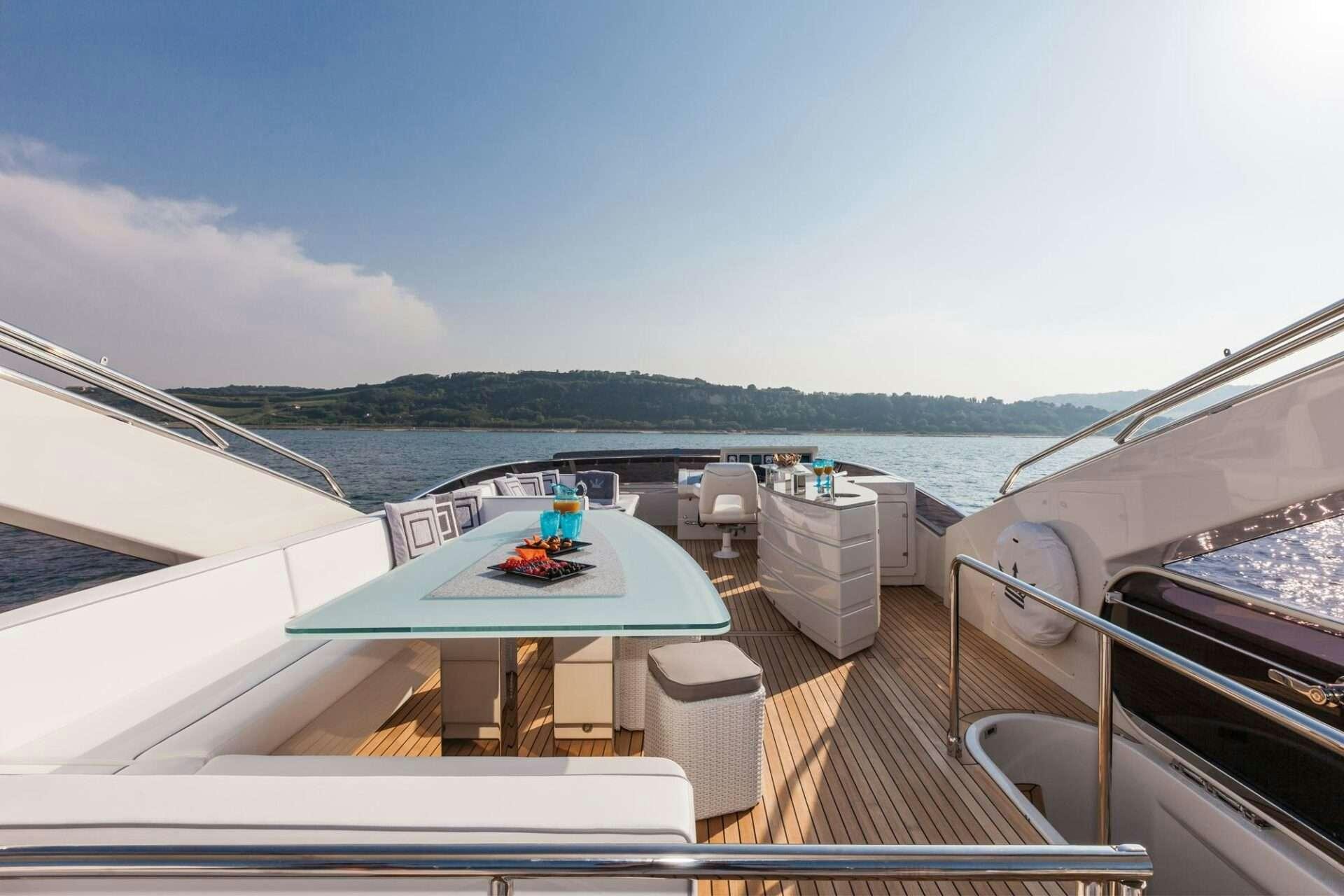 a deck with a view of the ocean and mountains aboard WHY NOT Yacht for Charter