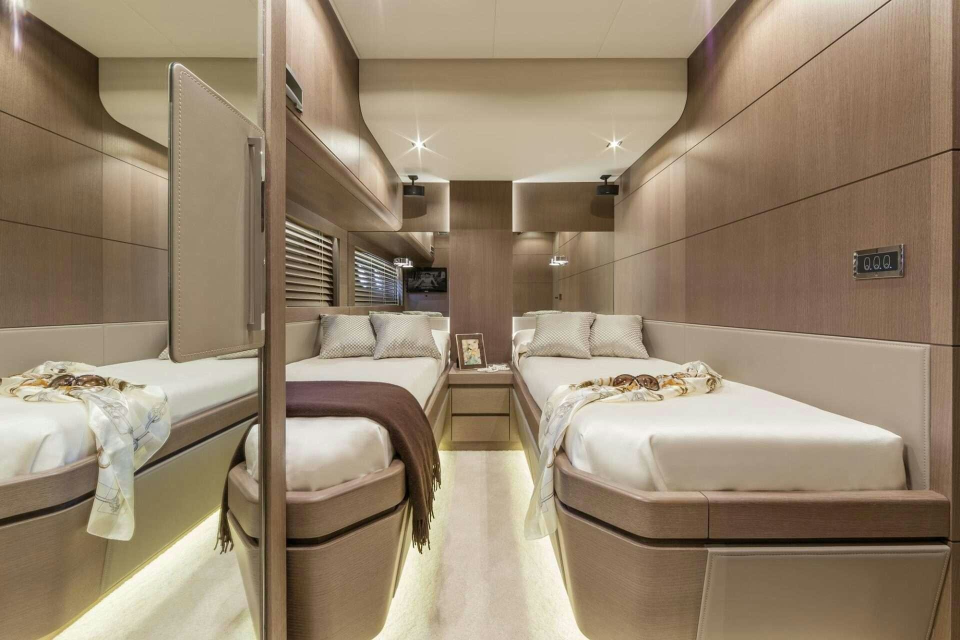 a room with beds and a chair aboard WHY NOT Yacht for Charter
