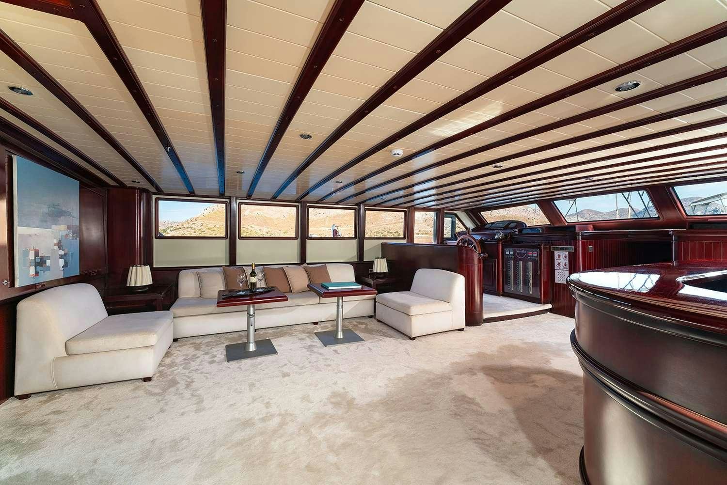 a room with a couch and a table and a tv aboard ALWAYS SMILE Yacht for Charter